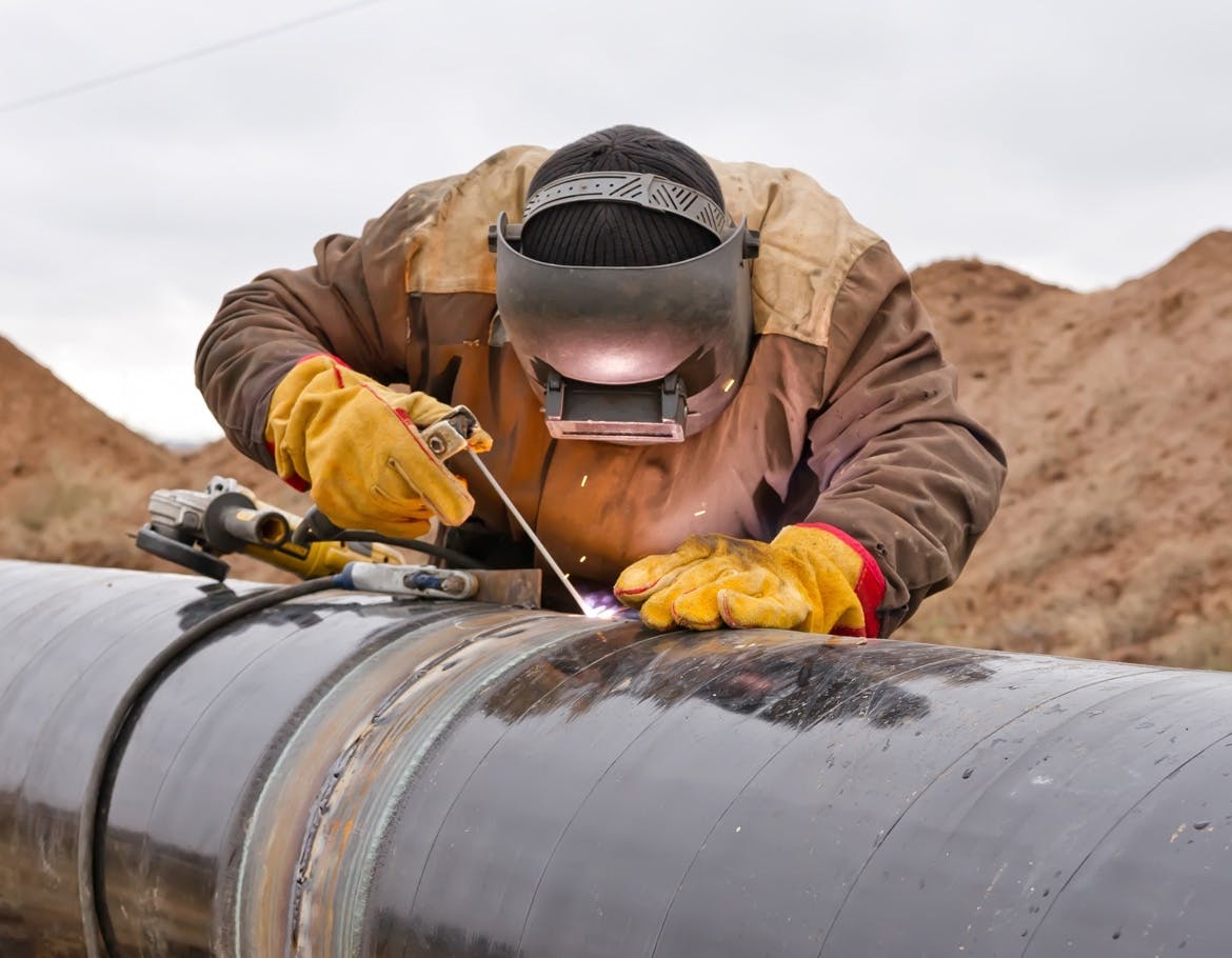 Pipeline welder repairing a pipeline joint.