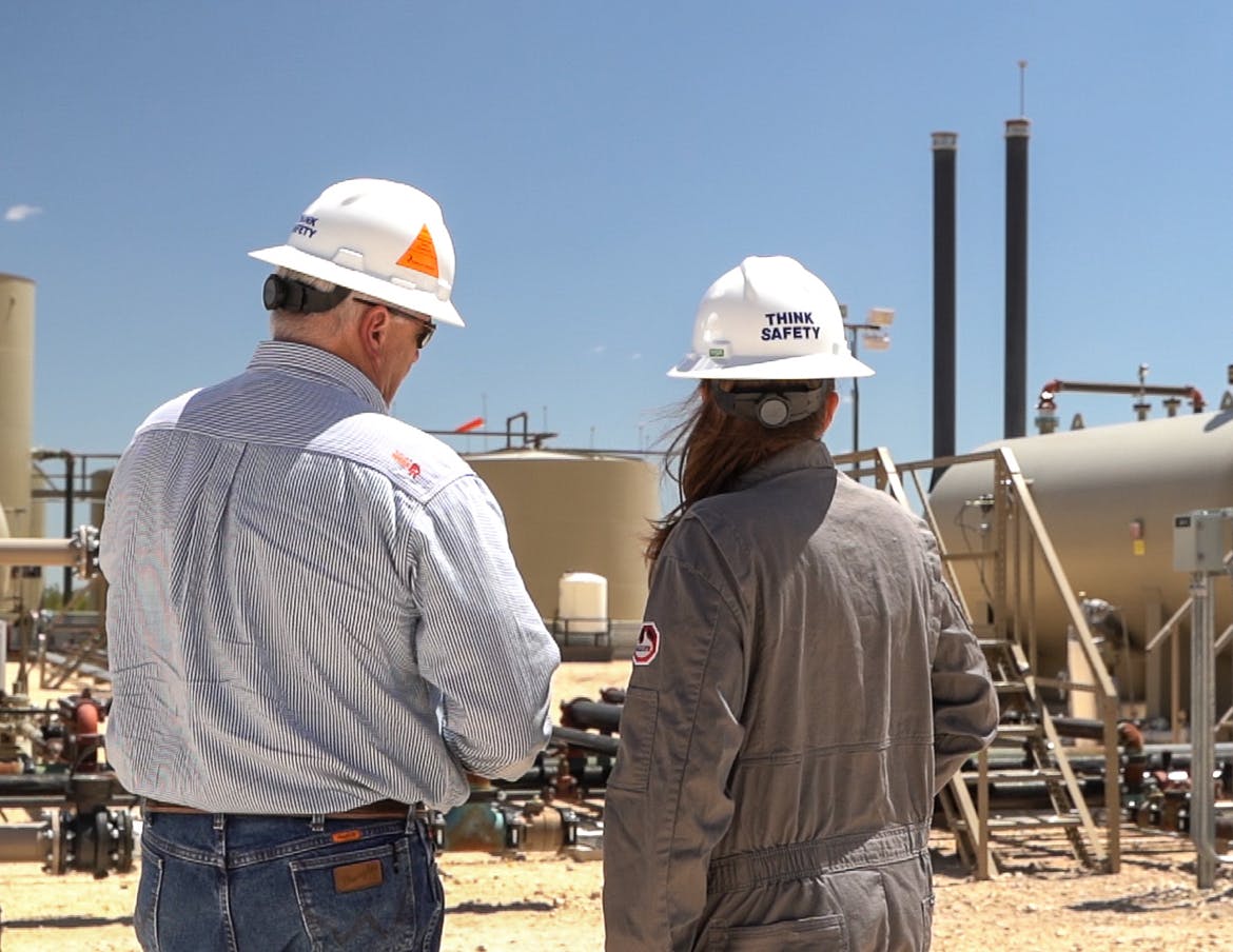 An HSE inspector goes over a report with an oil & gas contractor.