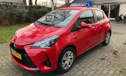 Nieuwe rode Toyota Yaris als automaat lesauto