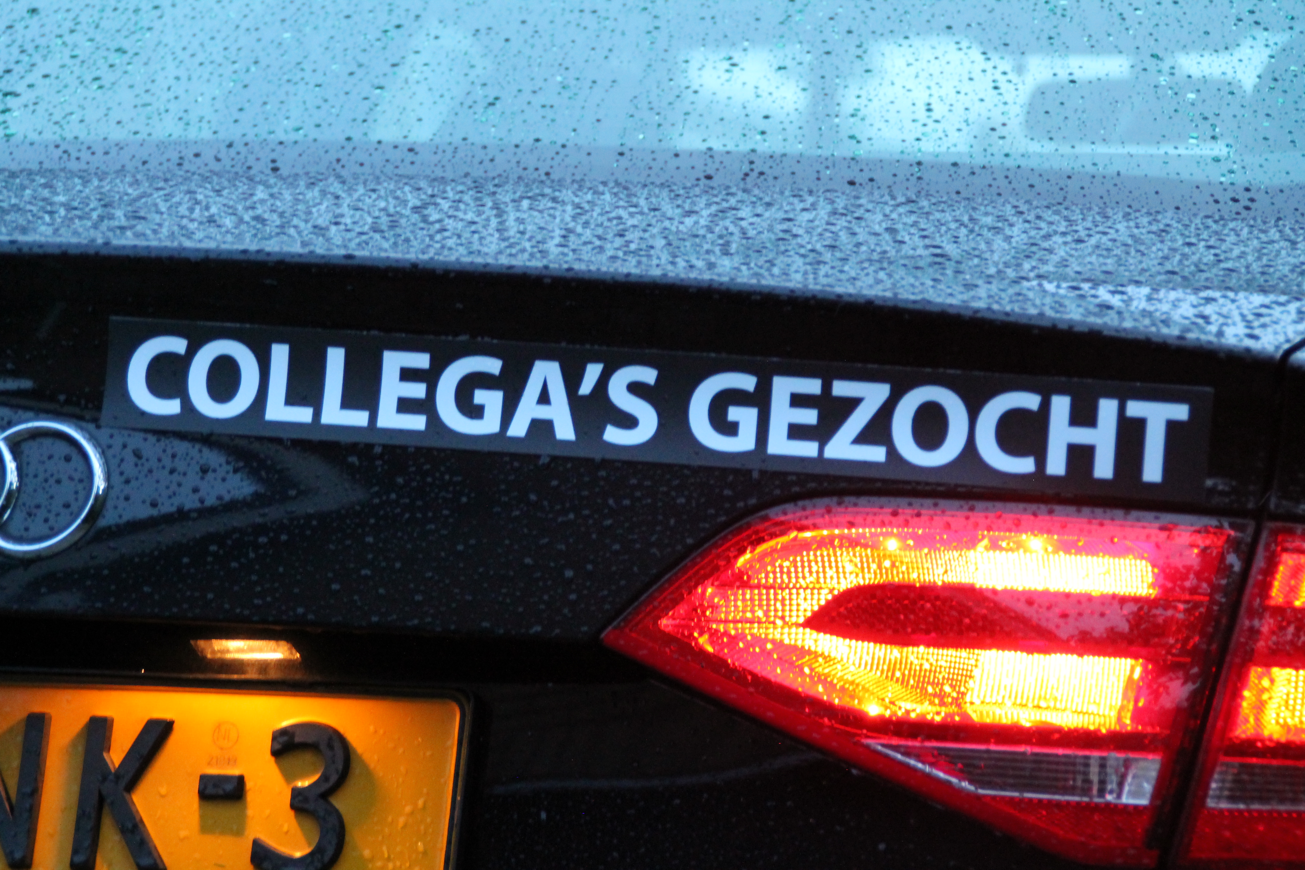 Afbeelding van de kofferbak van de Audi A4 lesauto met sticker met de tekst "Collega's gezocht" 