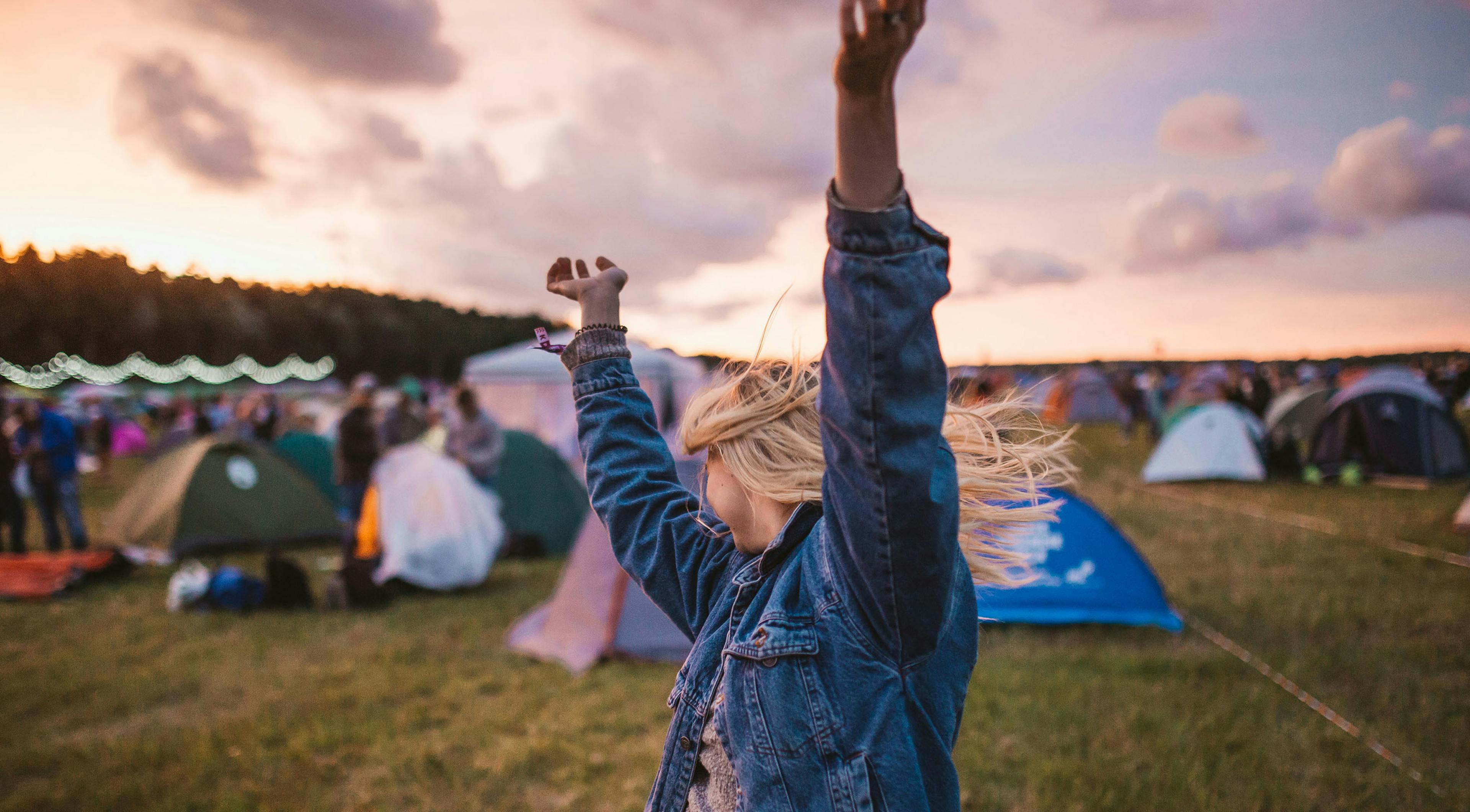 woman with arms in the air at sunset