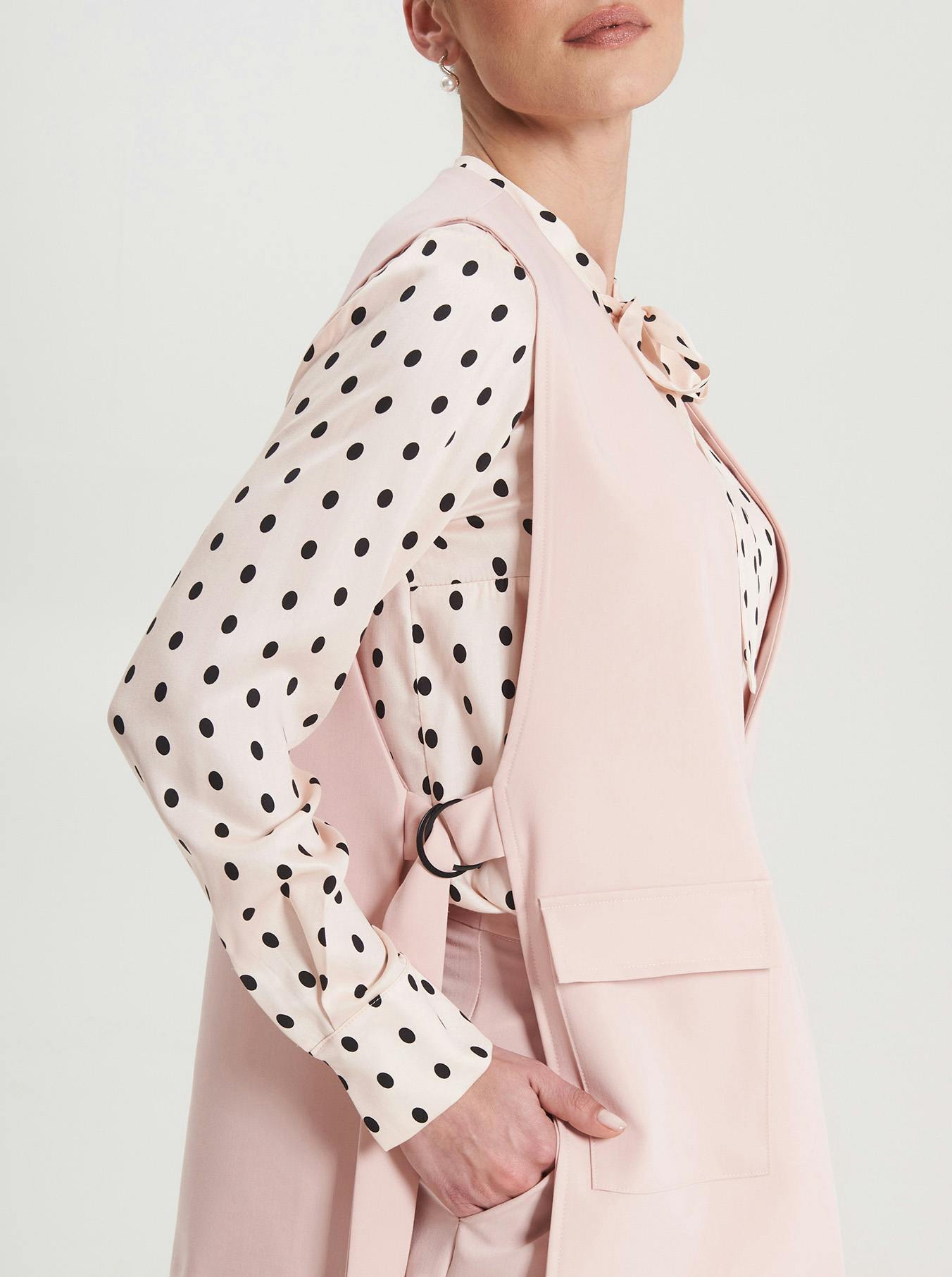 Modella che indossa gilet rosa cipria e camicia a pois Rinascimento