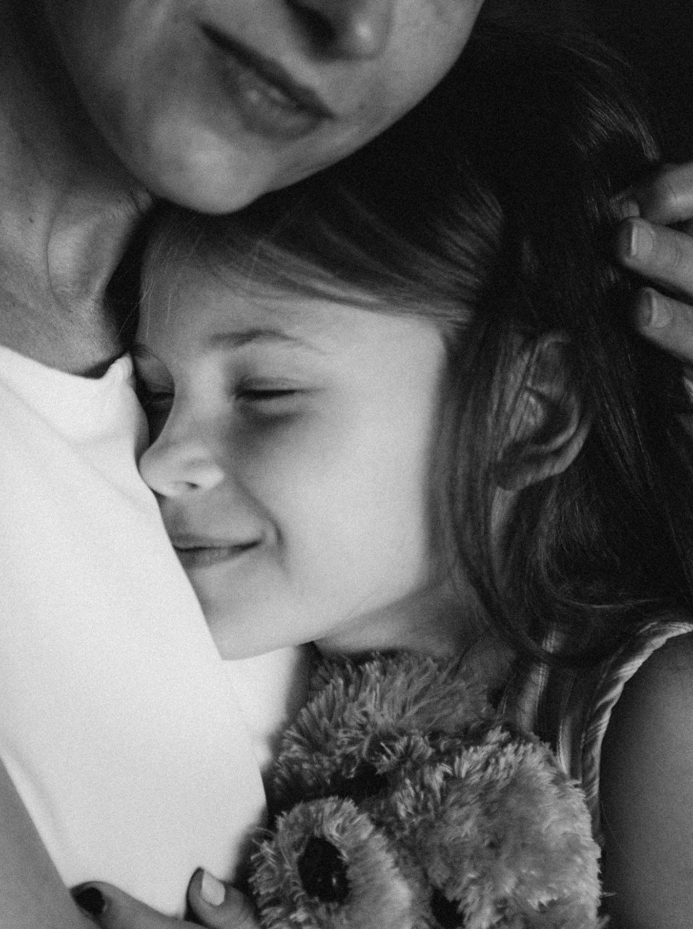mamma e bambina che si abbracciano e orsetto di peluche