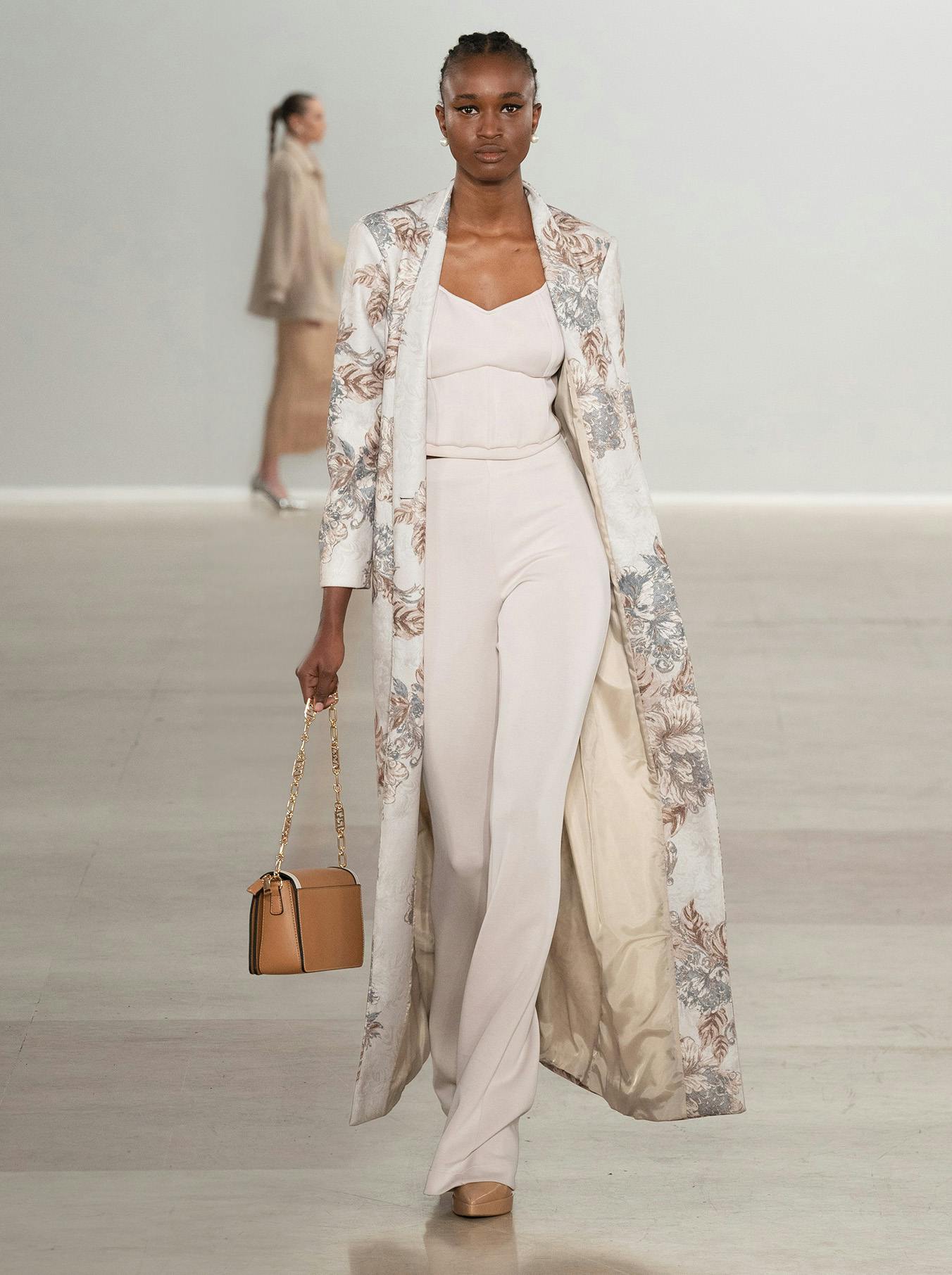 modella con completo bianco e borsa marrone