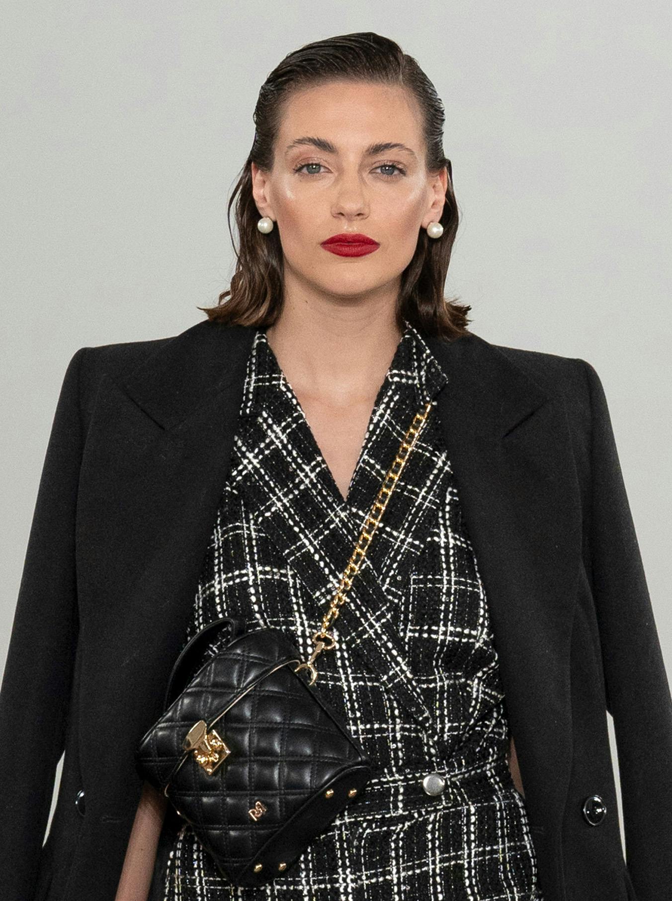 modella con rossetto rosso e abito e giacca nera