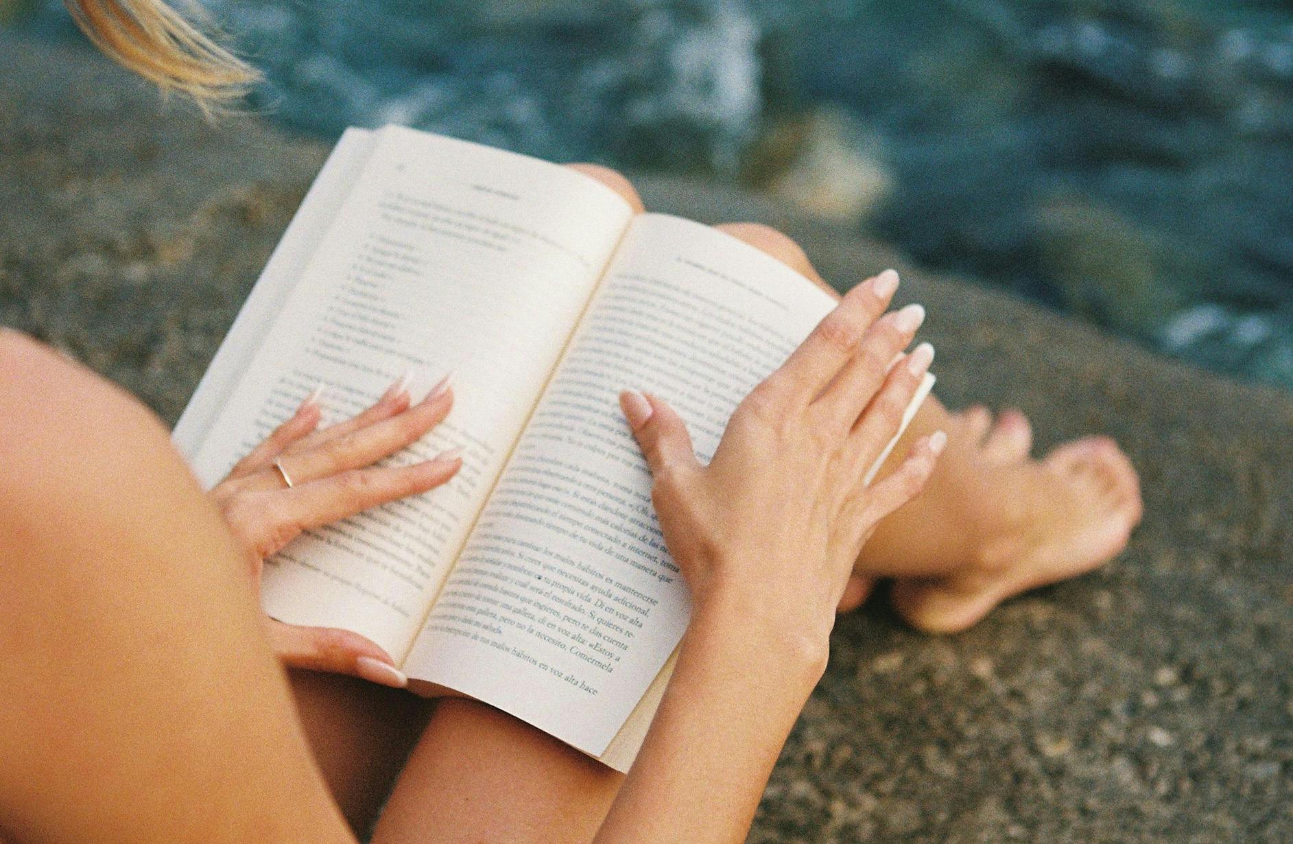 Persona che legge in spiaggia