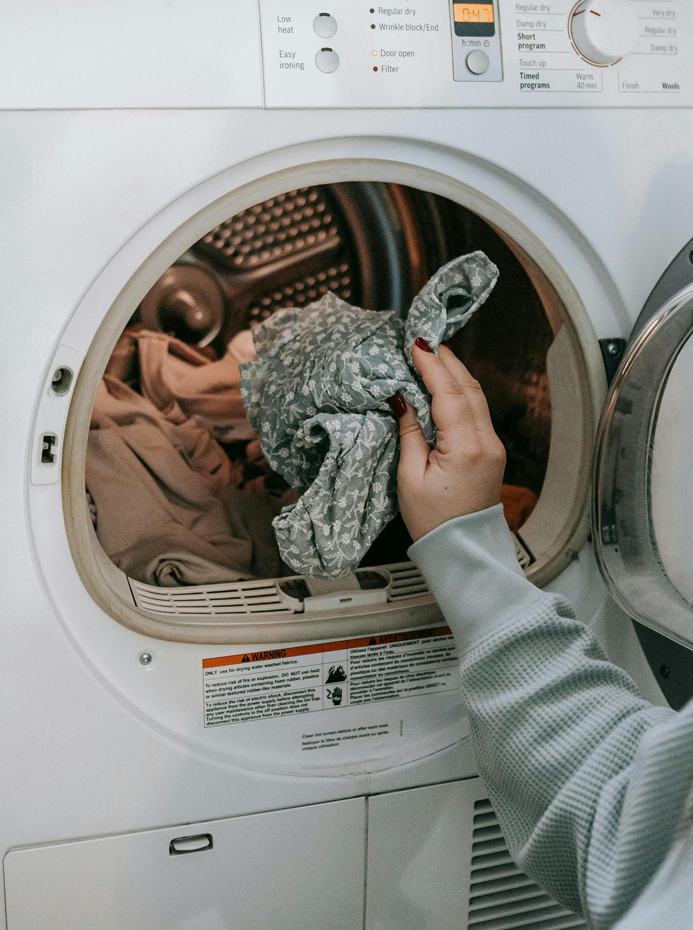 Persona che inserisce i panni in lavatrice