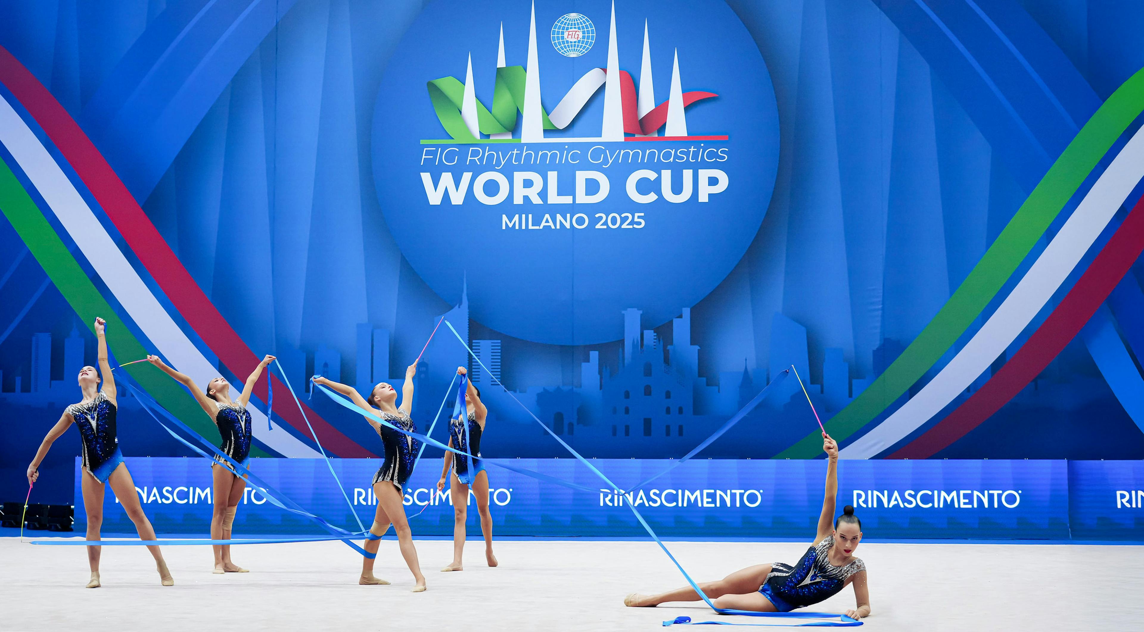 FIG Rhythmic Gymnastics World Cup, Milano 2025. The backdrop is blue with colorful stripes.