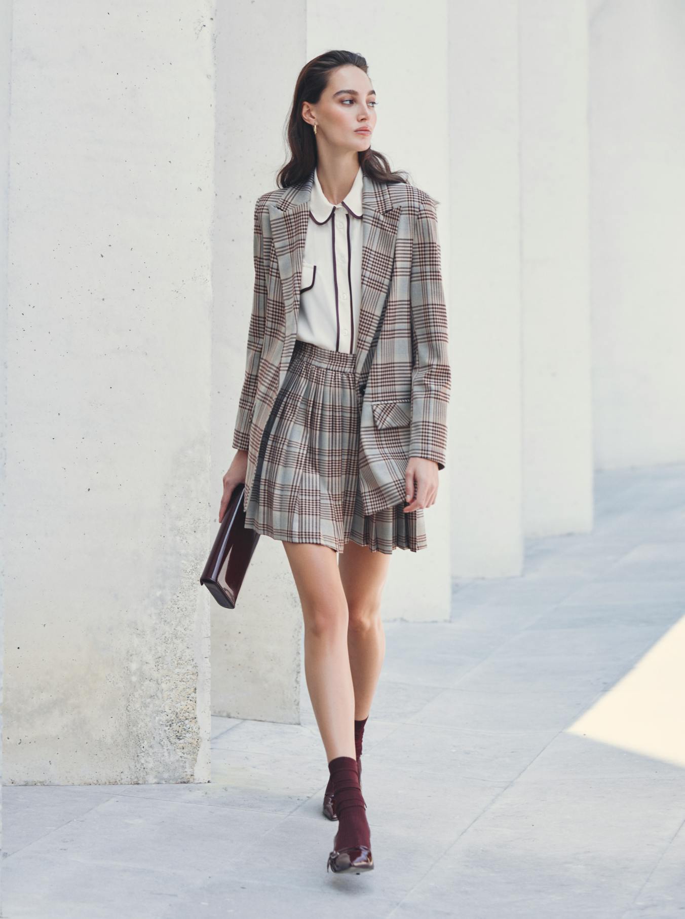 Completo tailleur con gonna a pieghe e pattern a quadri