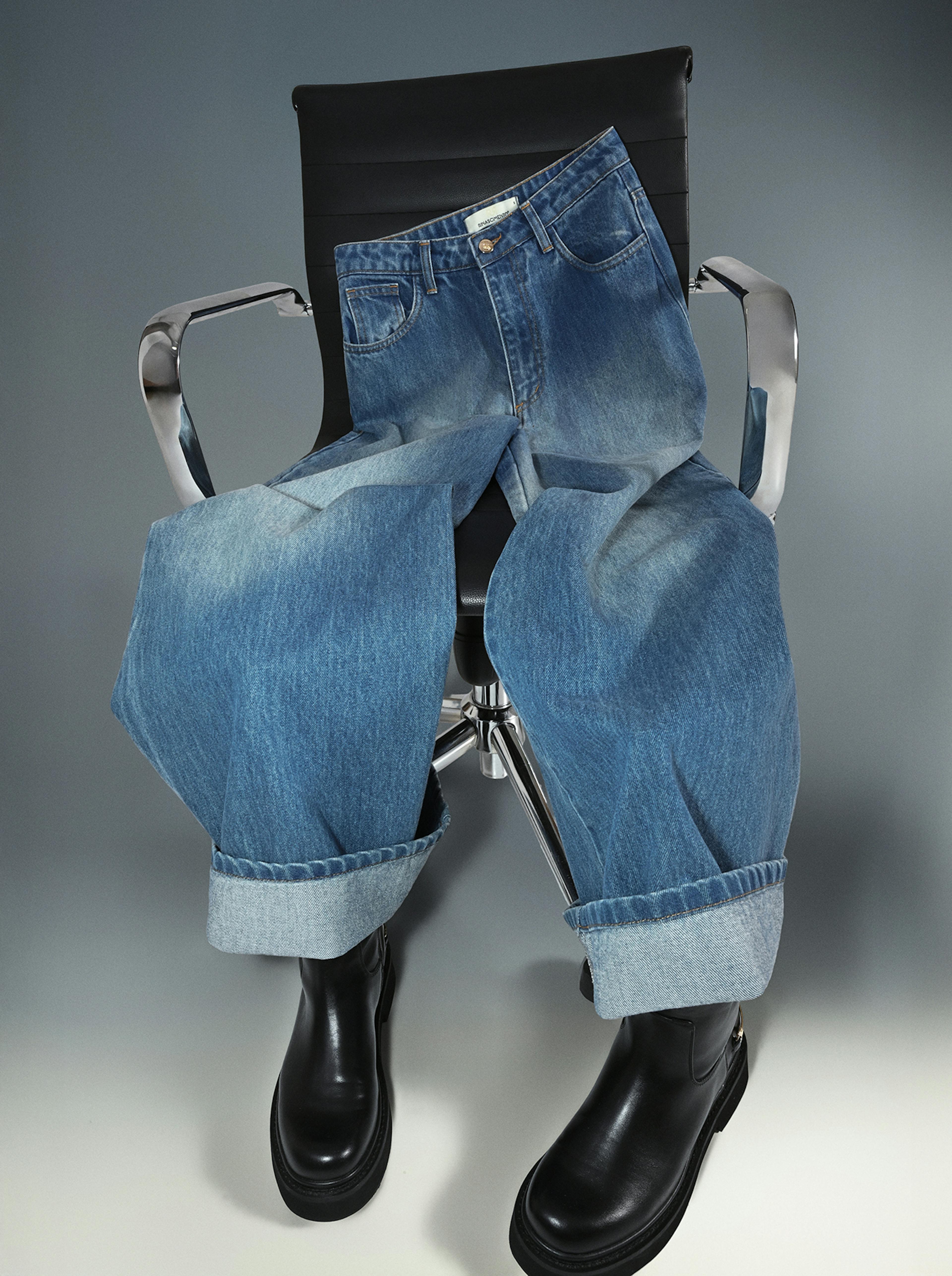 A chair displaying a pair of blue denim jeans and matching black boots.