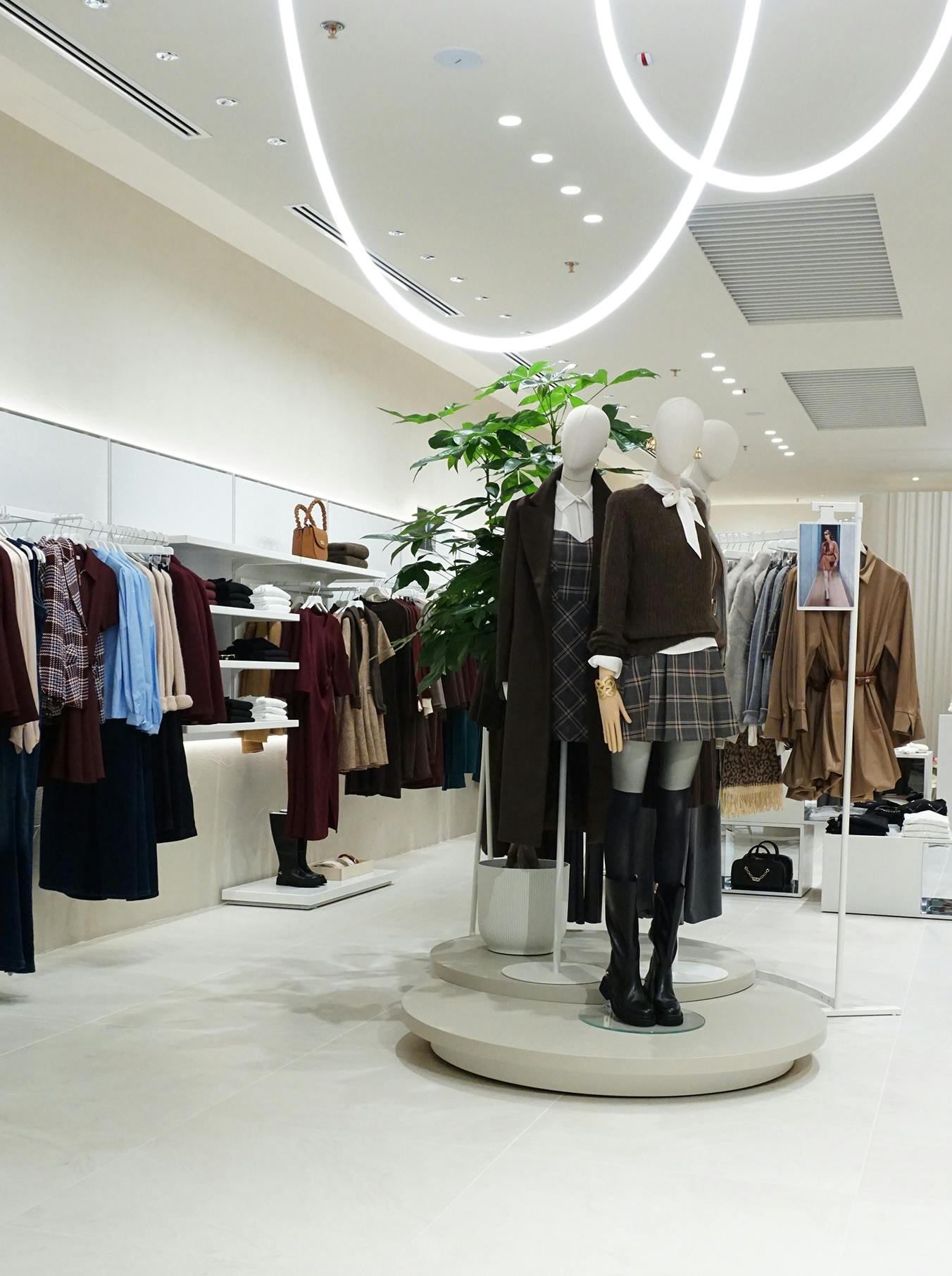 Fashion store interior with mannequins wearing coordinated fall outfits. The space is bright, modern, and organized, with a chic, inviting ambiance.