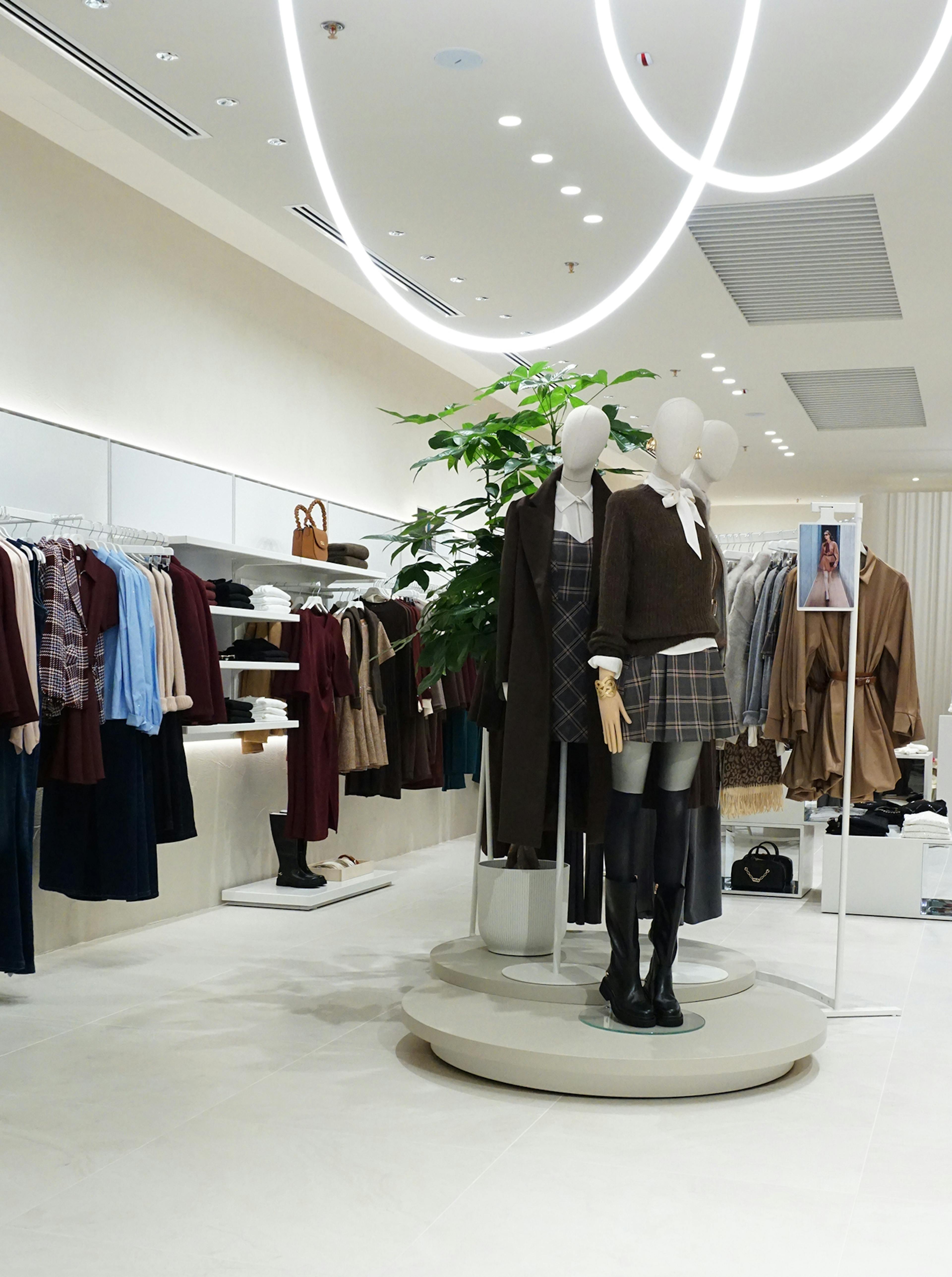 Fashion store interior with mannequins wearing coordinated fall outfits. The space is bright, modern, and organized, with a chic, inviting ambiance.