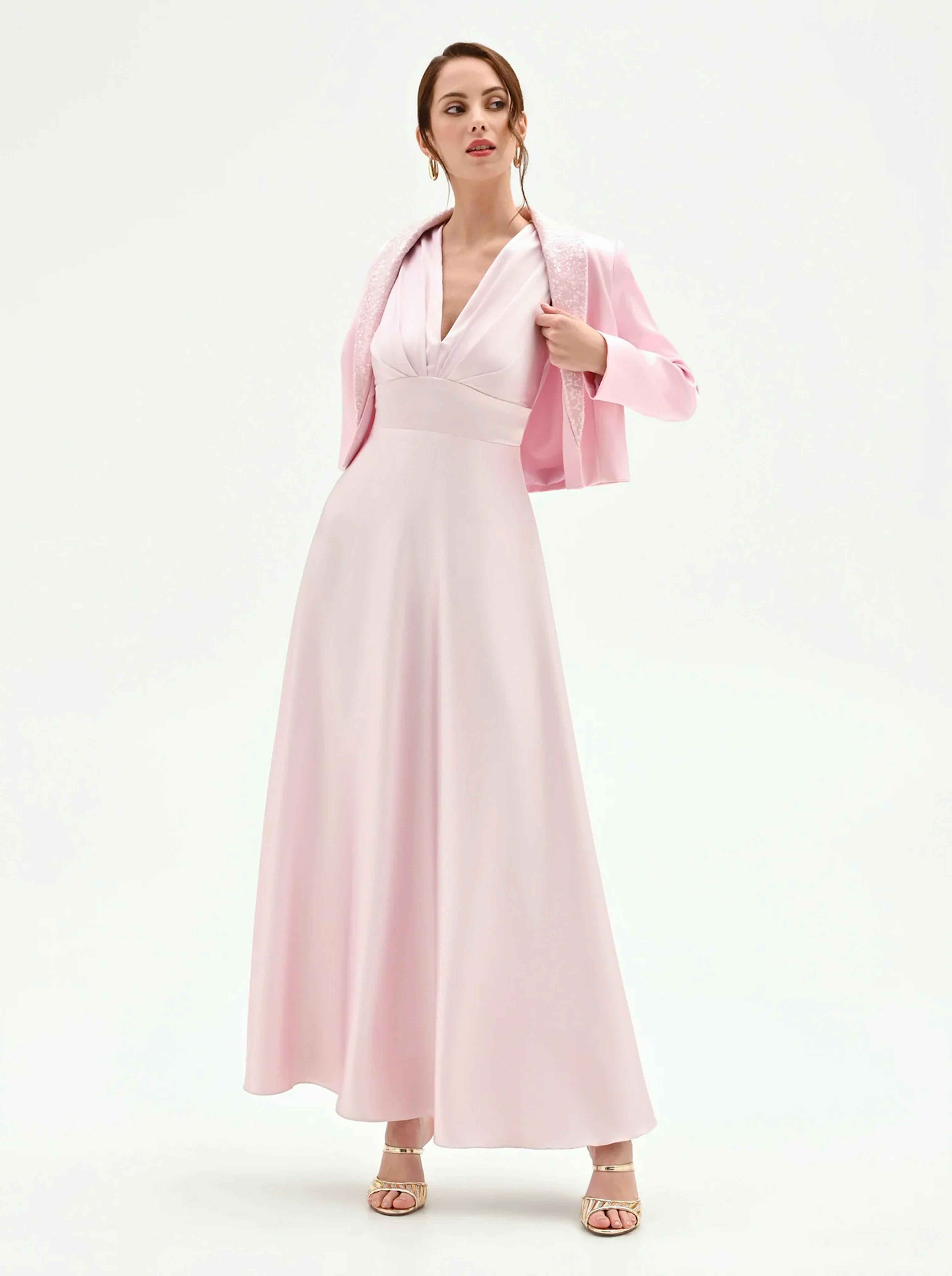 A model showcases a stylish pink dress paired with a matching jacket, exuding elegance against a simple white background.