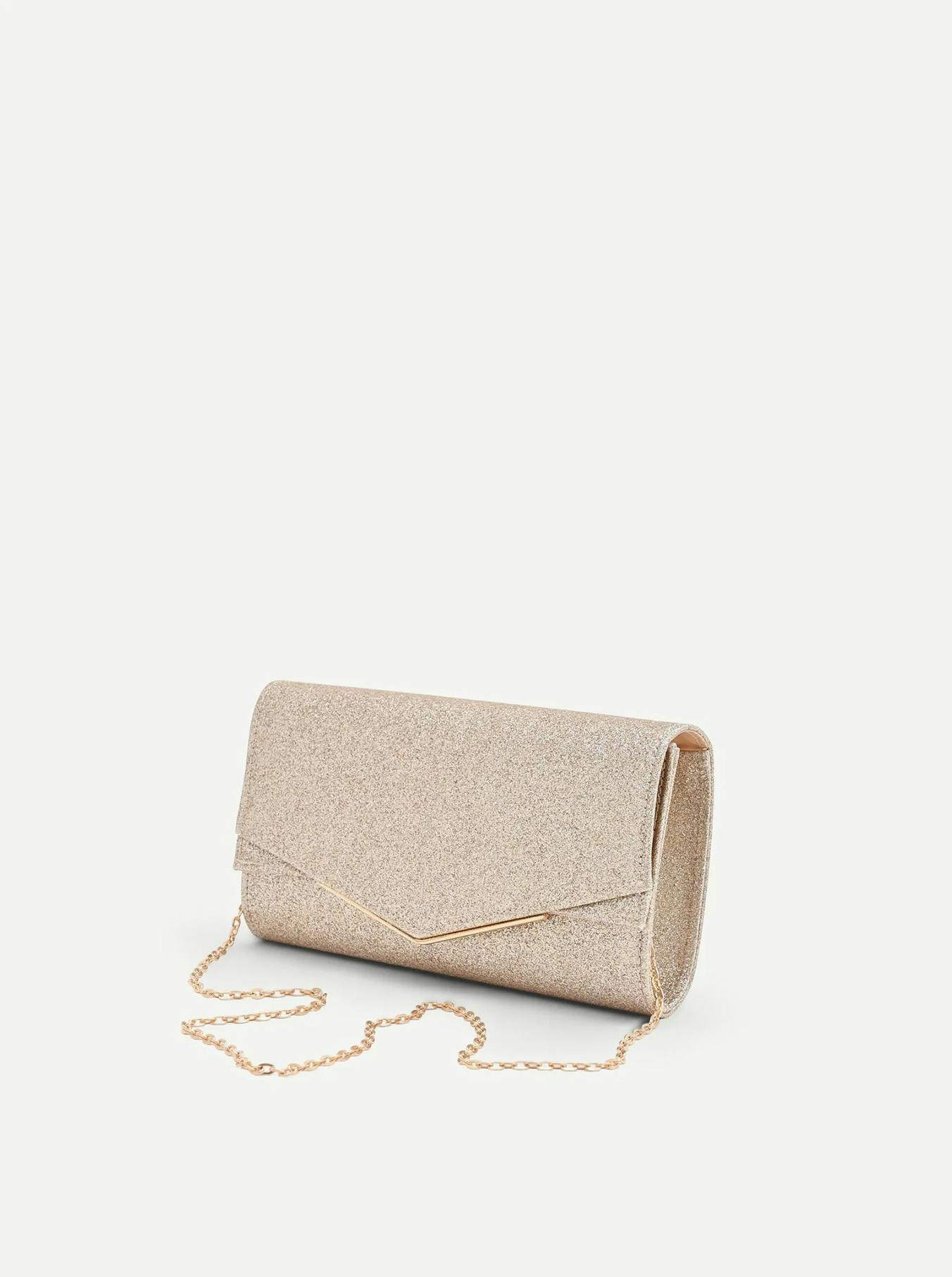 A gold glitter envelope clutch with a gold chain strap, displayed against a plain white background.