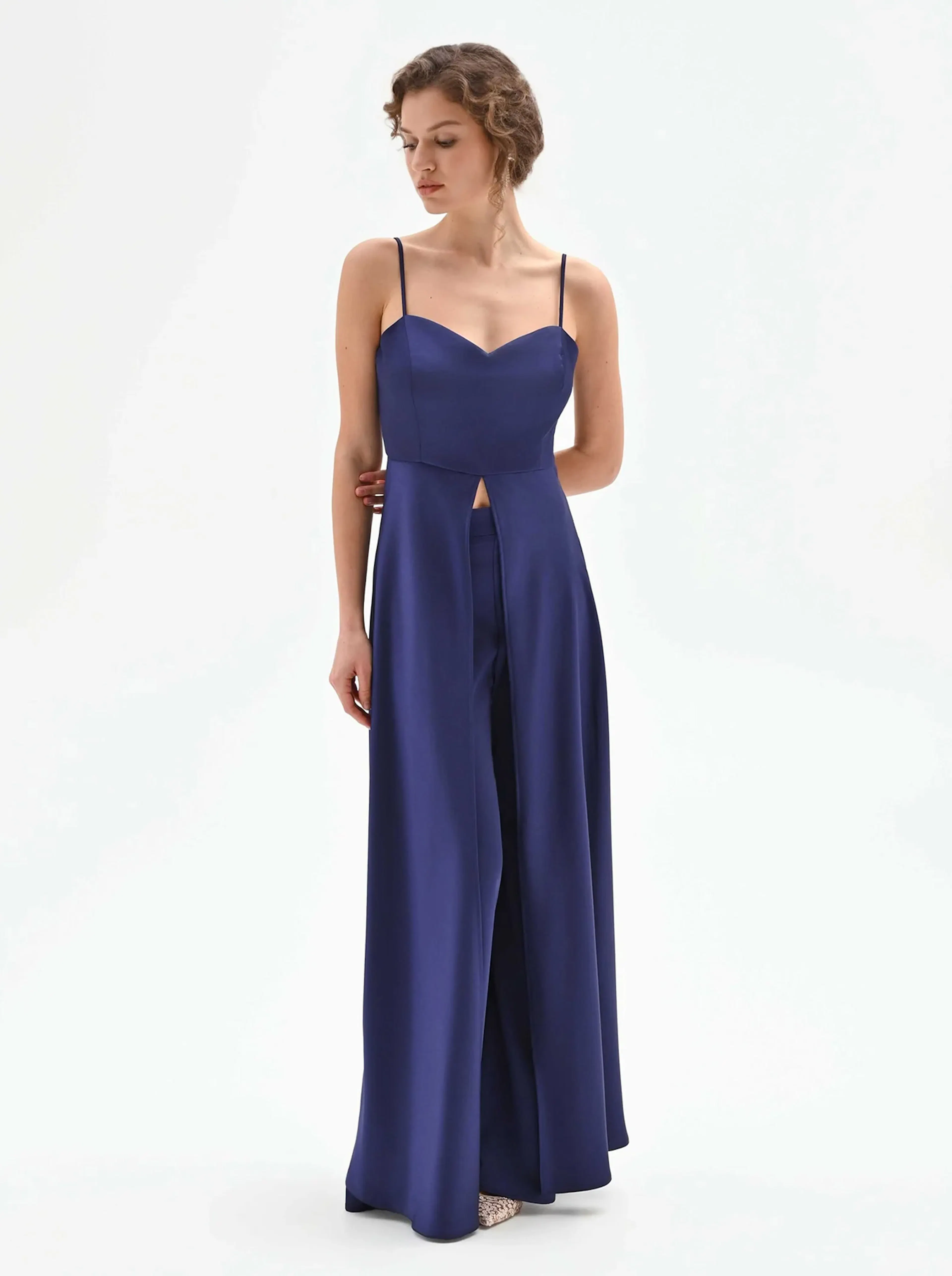 A model wearing a stylish navy blue jumpsuit with a sweetheart neckline and a front cutout, standing against a plain background.
