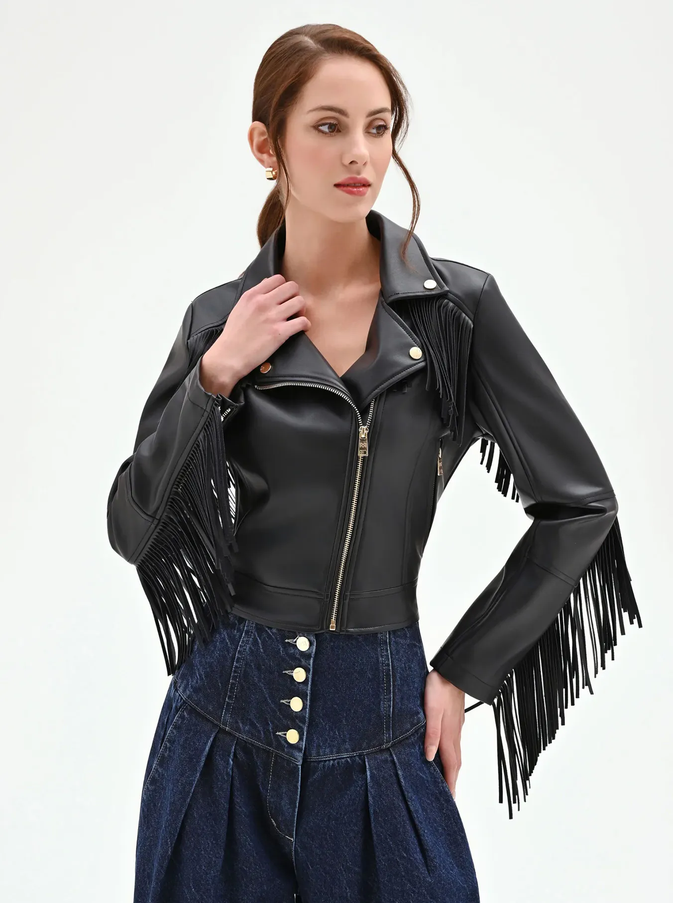 Woman wearing a black leather fringe jacket with gold zippers