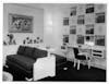 Salon des Arts Ménagers : ensemble de salon avec deux divans séparés par un muret pouvant se déplacer, permet la possibilité d’un lit deux personnes. Casier mural avec motifs peints par A. Margat. 1950 © Chevojon/RINCK 