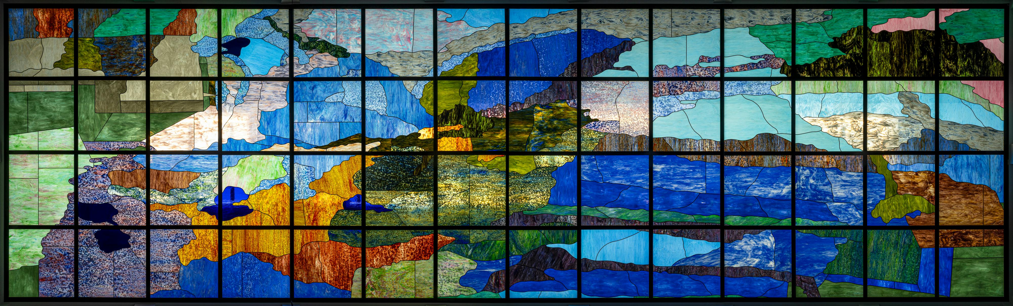 Language is a virus or Between Immerwahr and me: Hoover! As he saw it, the true problem with the economy was neither the injustice of capitalists nor the impatience of workers, but the inefficiency of objects So much time and money were wasted on things that just didn’t work Standardizing and simplifying were, in his mind, the keys to prosperity Tires must have at least 70 percent new rubber on their treads Red ink had to be a certain proportion of scarlet dye to water… A senator: The screw thread is a simple device but it ties together the whole mechanical skeleton of our civilization, or it doesn’t Setting standards on the mainland was hard work It went easier in the territories Authorities just declared standards and enforced them Fashioning a binding together, another system of base measure, set, put nonsense like A hurdle, a basket, grided, a small net, a lattice, a mesh, a net, a screw thread, on the violences of a map, of specificity and exploitation With a map of the minerals they will mine If they don’t make rules the mining happens Who gets to make that choice and who gets to suffer from it and wait why did they make that choice and what were they thinking of, what were they modeling themselves on? Empires imprinted colonies with new laws, ideas, languages, sports, military conventions, fashions, weights and measures, rules of etiquette, money and industrial practices In fact that’s what colonial officials spent much of their time doing There’s a reason, in other words, that the British measurement system (feet, yards, gallons, pounds, tons) is called the imperial system… Empires standardized people, too How do I figure out if I have been standardized can I take a quiz? This is about balance and the arrival of the passerby How’d you come to pass by anyway 91 percent of the world’s population stops at red octagons Standards make things accessible to those who hold the standard You had to colonize to standardized, roughly speaking (and with important exception) What changed in the Second World war was scale The United States took advantage of its position – as the undisputed economic and political superpower, with its wartime logistical network, installed in more than a hundred countries to push its standards beyond its borders The wave of US centered standardization that followed transcended the scale of the nation or the empire This was standardization at the scale of the planet! Great We could also say: it is broken and we won’t be fixing it Always perpetrators, and with pollution always victims, never a bride, never a bottom Could the grid be for us all? The grid is you, I mean me, I mean the translating, the reading Can a place be written? Can land have surface, like if it has such variance? What’s so different from colonialism and globalism, domination without annexation Who set the standards again Variable Just kidding we just discussed this Surface can be pierced The ocean is finite Jonathan told me it is not so vast that it cannot be imagined (Here it is right here). 2024 Reproduction Tiffany Stained glass with steel frame 4.8 × 14.8 m This work’s long title above quotes from historian Daniel Immerwahr’s book, How to Hide an Empire (2019, Random House) which considers the implications of American colonization. This work focuses on the Pacific Ocean wondering through Immerwahr’s language and the work’s material and scale” what is the use of a map you cannot read? 