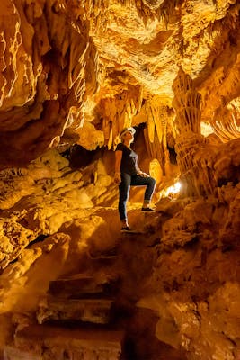 Imagem impressionante do interior de uma caverna com cores vibrantes de laranja e amarelo, criando um cenário natural deslumbrante para os amantes da natureza.