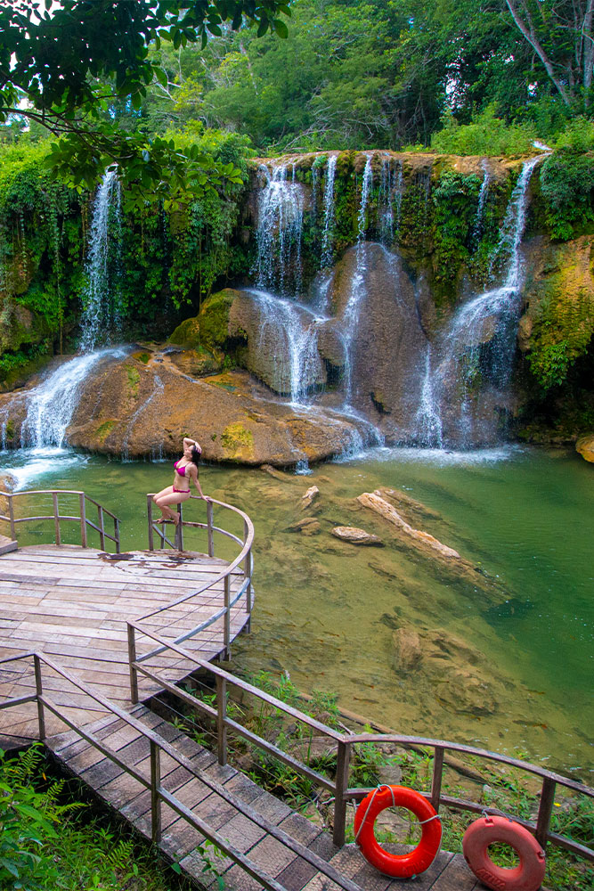 Paisagem natural com cachoeiras e piscinas naturais em um ambiente exuberante, ideal para contato com a natureza e atividades ao ar livre.