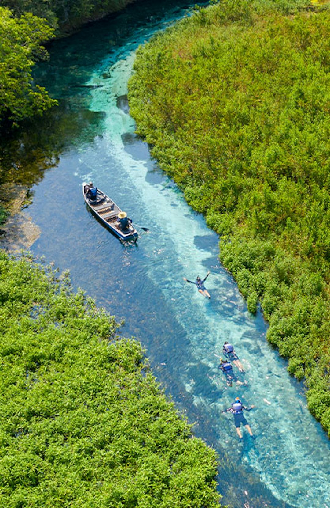 Barco de apoio para flutuação em águas cristalinas e vegetação ciliar impressionante