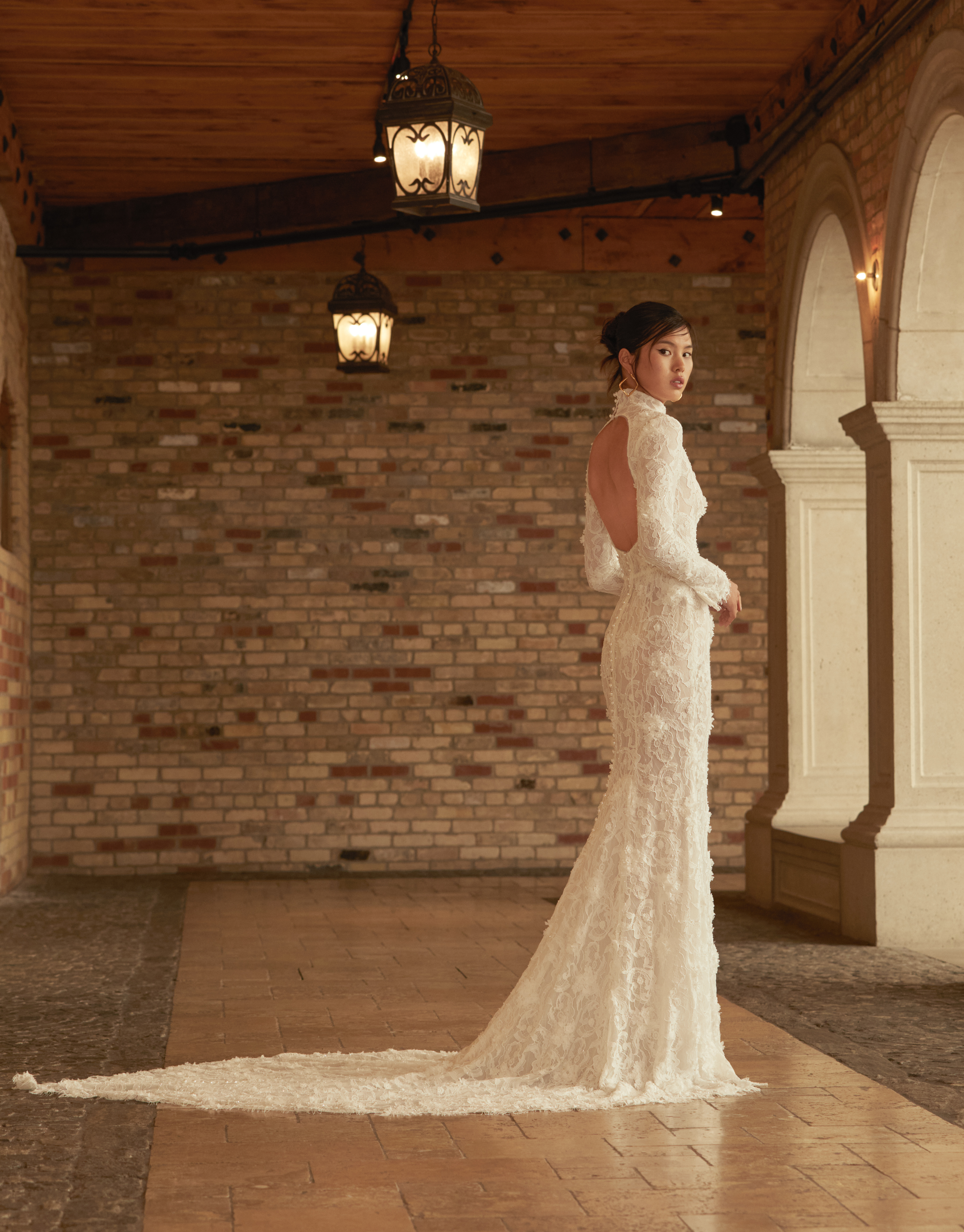 Bride wearing the Heidi sheath gown from the side, showing the fitted lace silhouette and train.