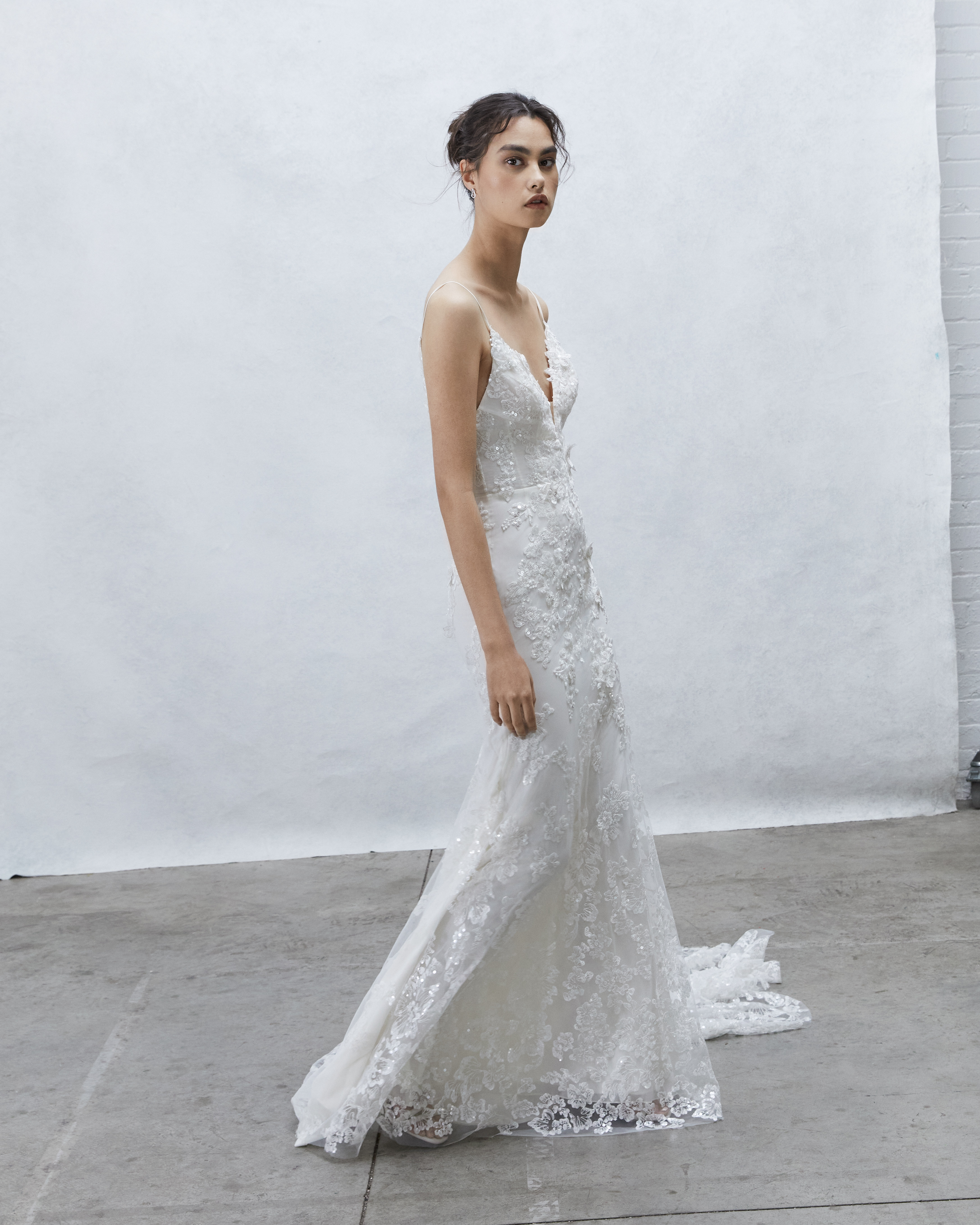 Side view of Nova embroidered lace sheath gown with deep V bodice and flowing skirt.
