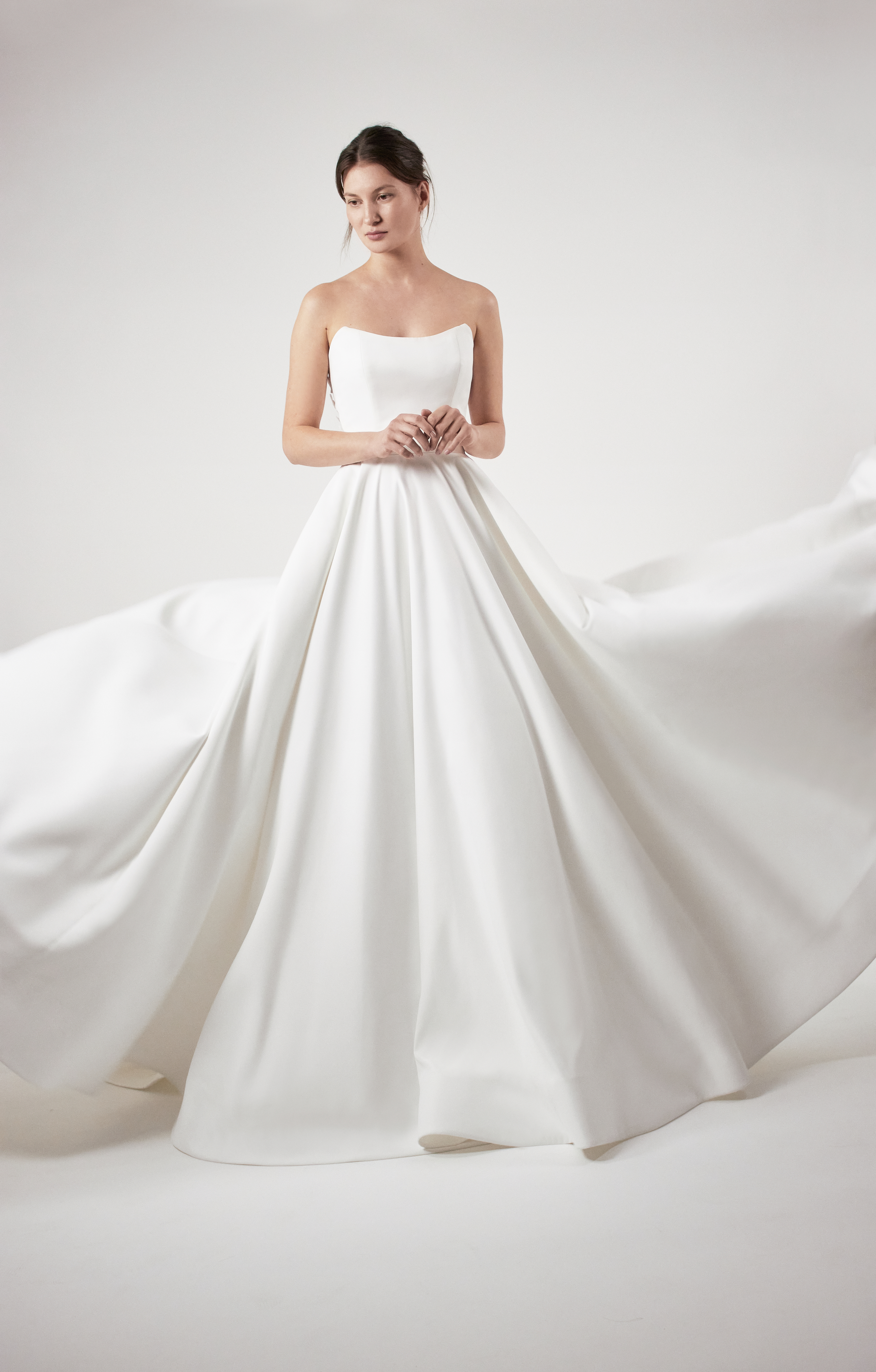 Makayla ivory ball gown with sculpted bodice, pockets, and voluminous skirt, shown from the front.
