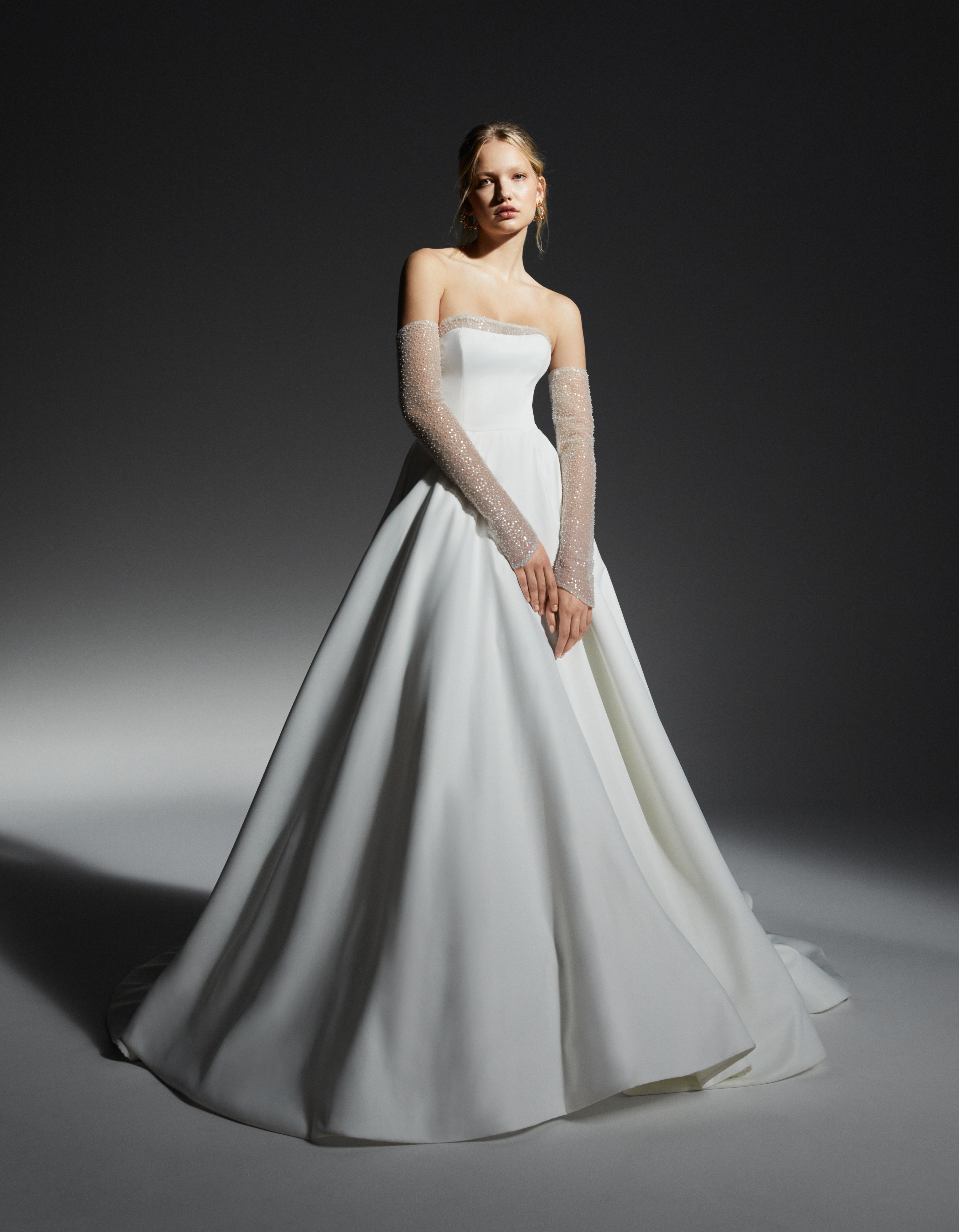Cassidy strapless ball gown with beaded lace neckline detail and detachable lace sleeves, shown from the front.