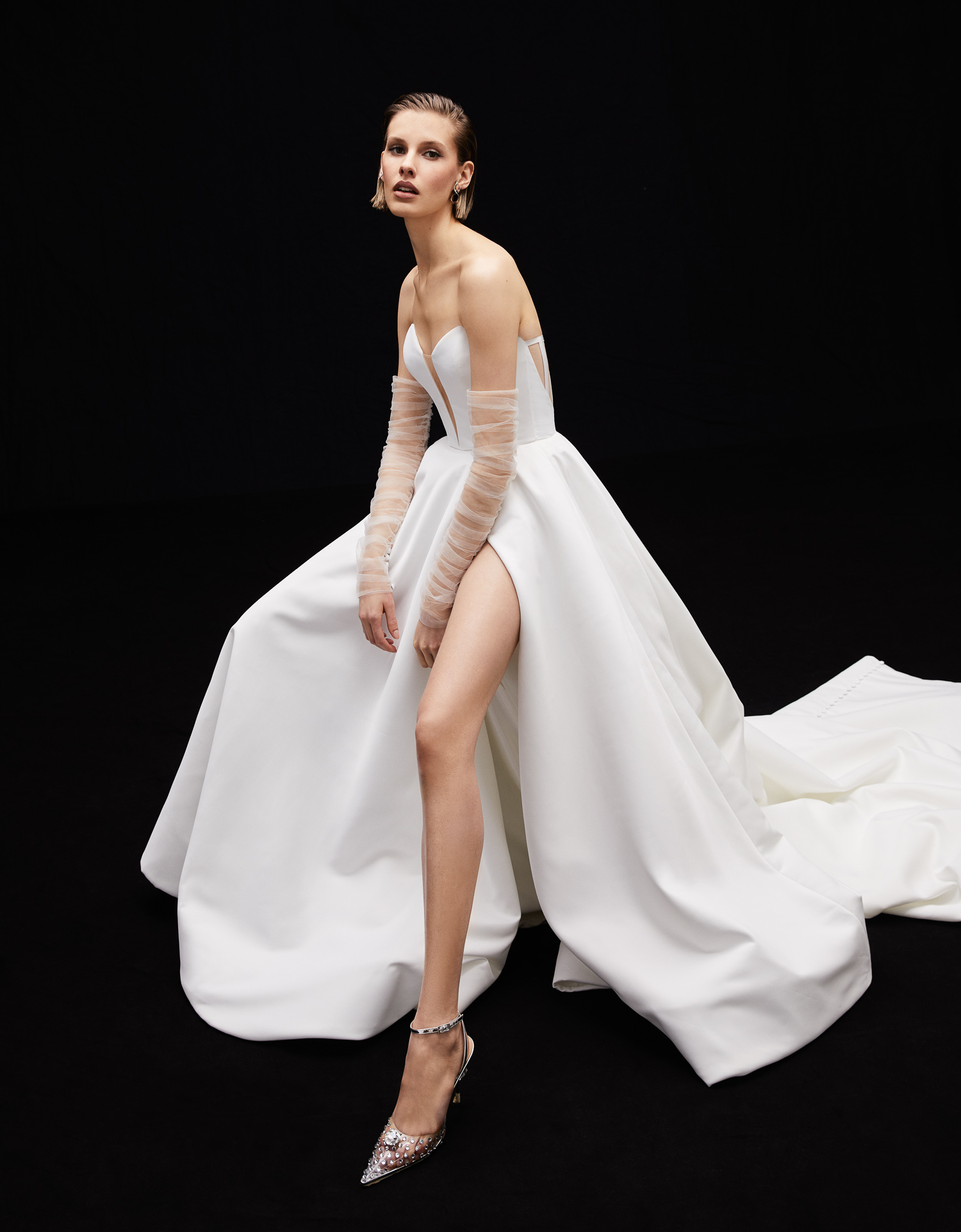 Side view of Stella matte satin ball gown with front slit, full skirt, and ruched tulle sleeve.