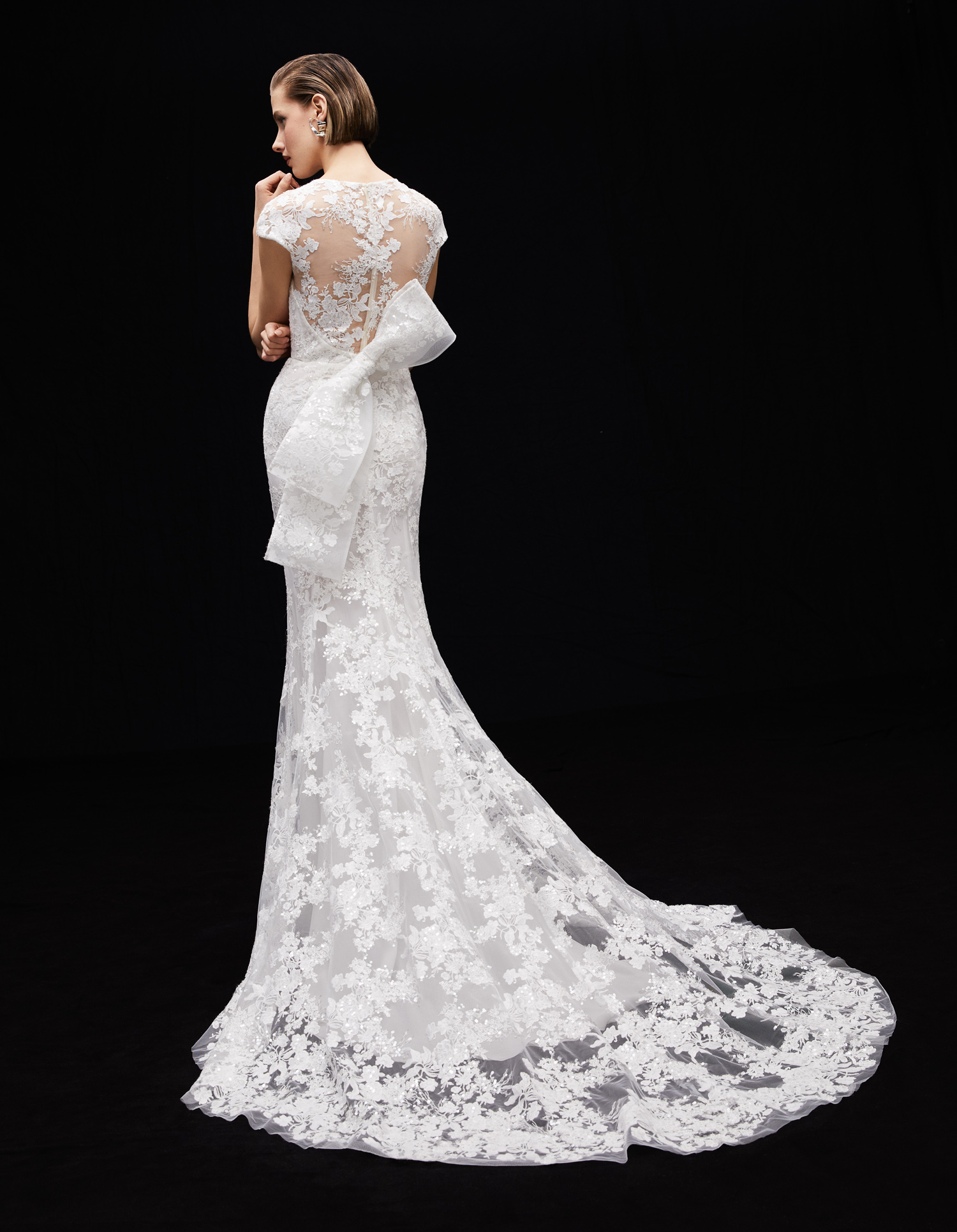 Back view of Ellie embroidered shimmer lace sheath gown with flutter sleeves and hand-applied floral lace train.