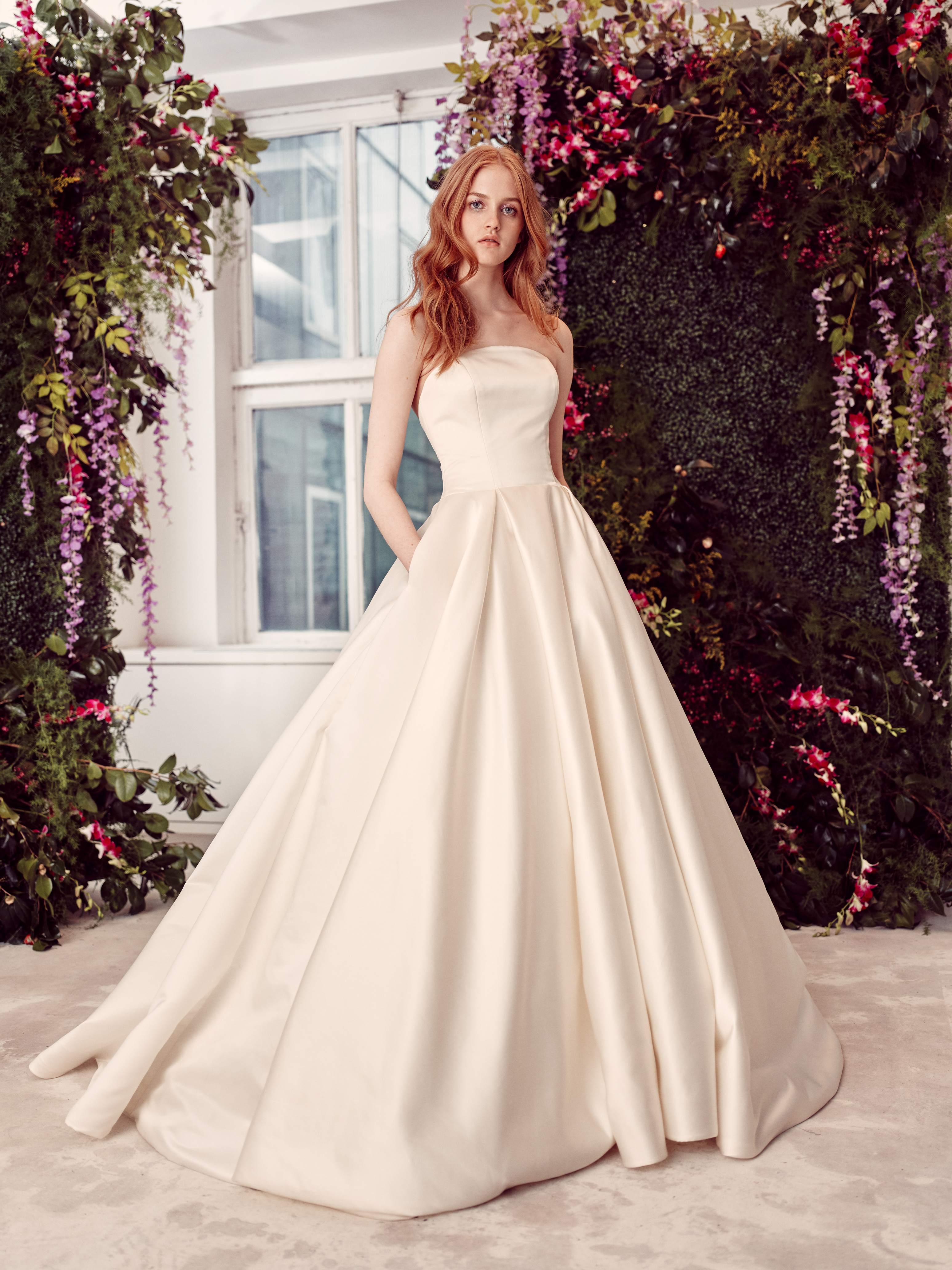 Payton ivory satin ball gown with kiss-pleated skirt and delicately arched neckline, shown from the front.