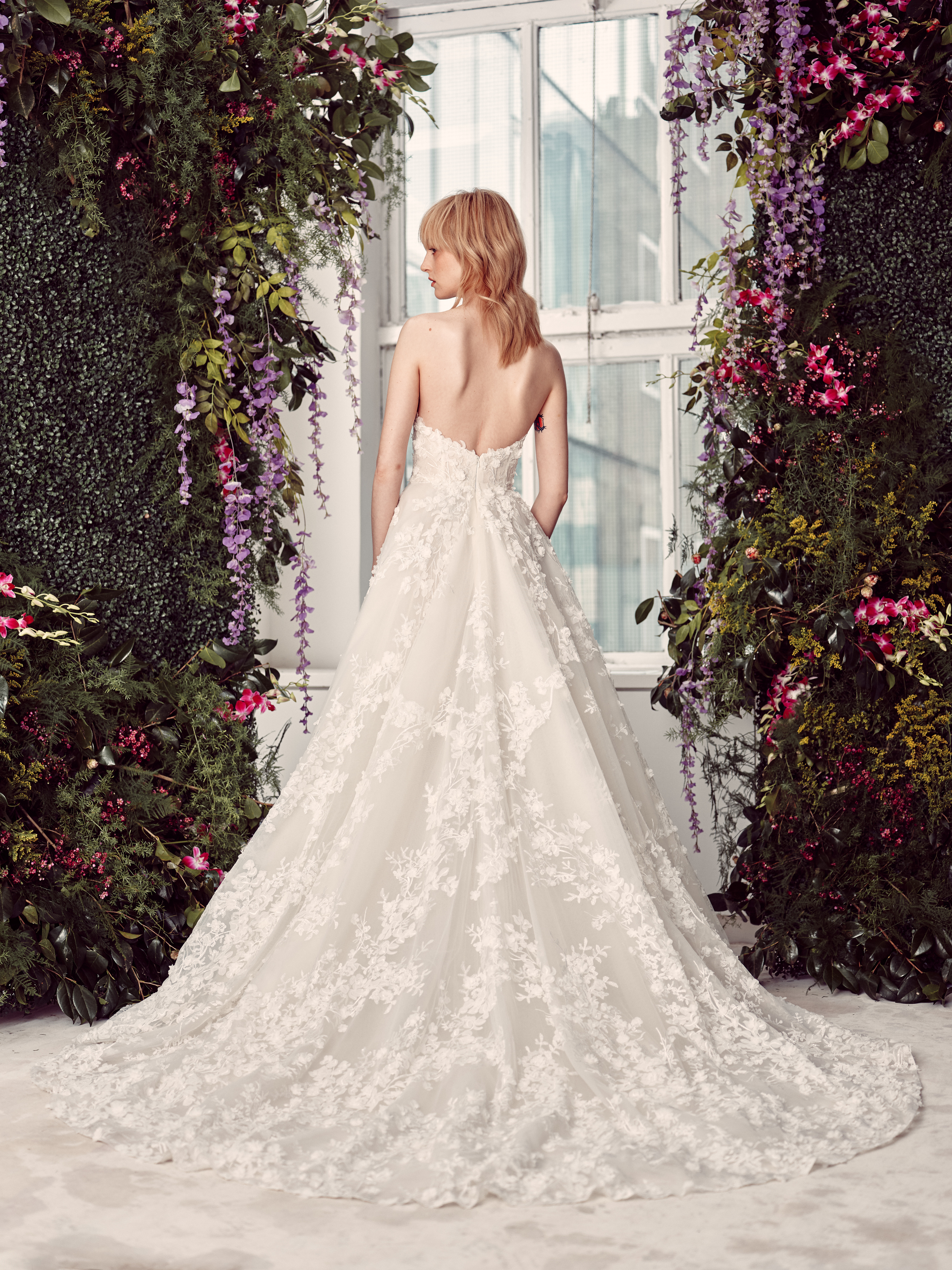 Bride wearing the Reagan ballgown from the back, showing the strapless bodice and full lace skirt.
