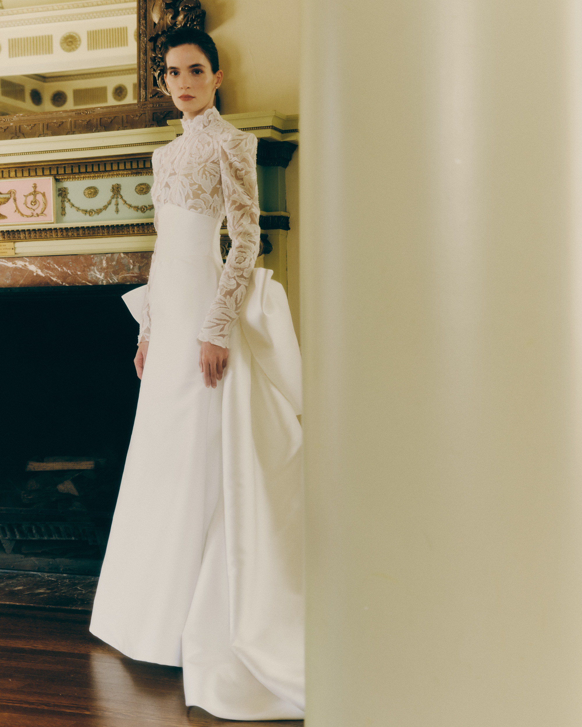 Bride wearing the Kit gown, showing the mock neck, translucent floral lace bodice, and fitted Neo-Satin skirt.
