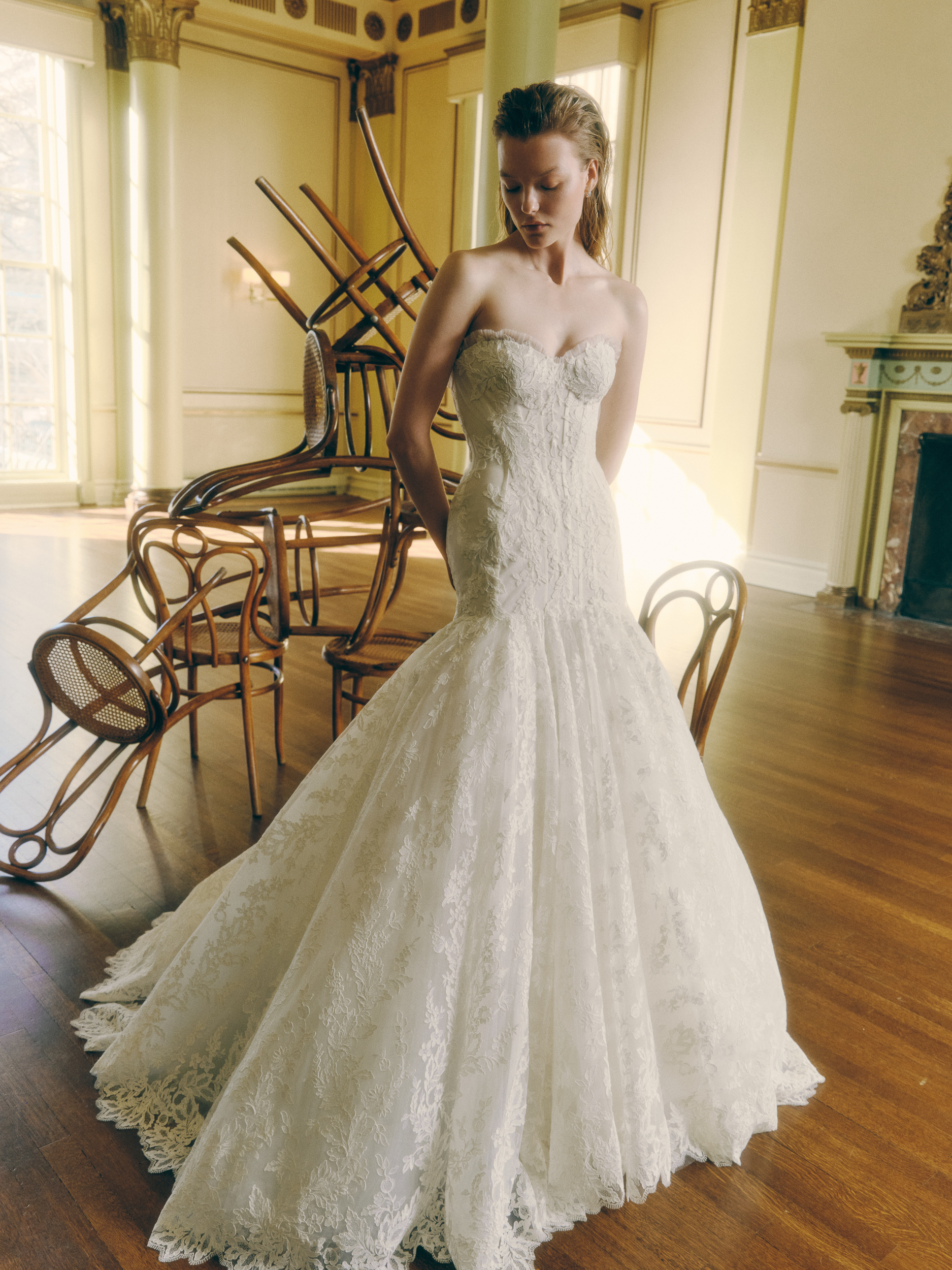 Bride wearing the Zay lace ballgown with elongated corset bodice and voluminous skirt.