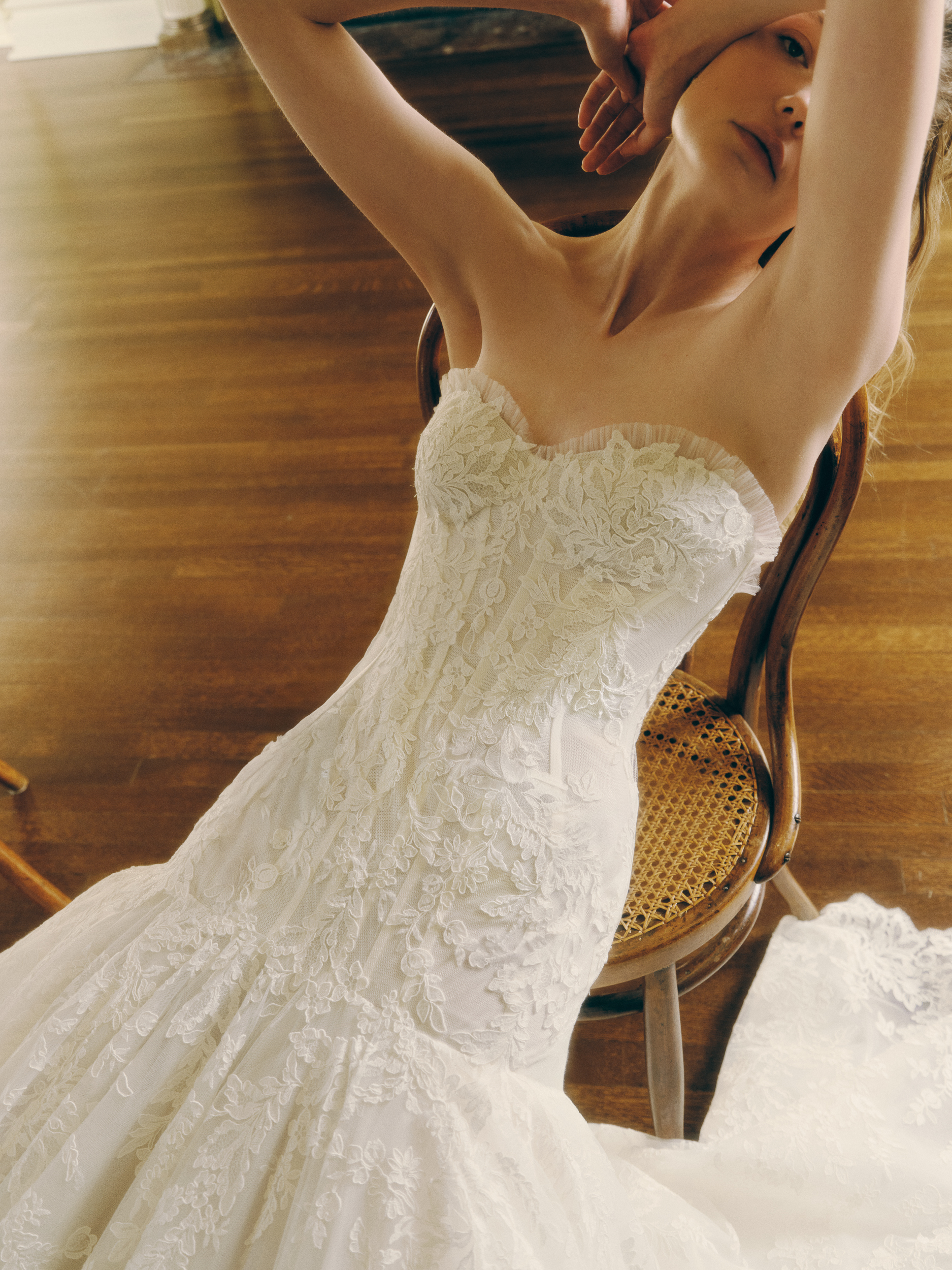 Close-up of the Zay gown, showing the elongated corset bodice, micro-pleated tulle neckline, and lace detail.
