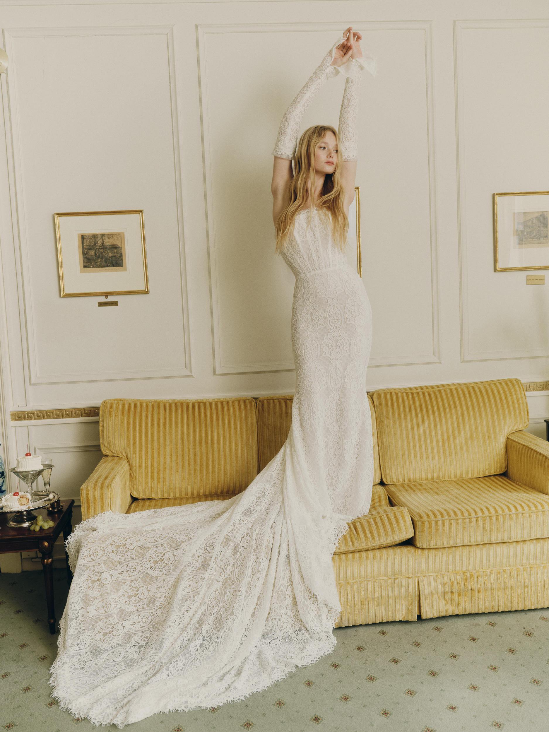 Bride wearing the Emme gown from the front, showing the fitted sheath silhouette, lace bodice, and opera cuffs.