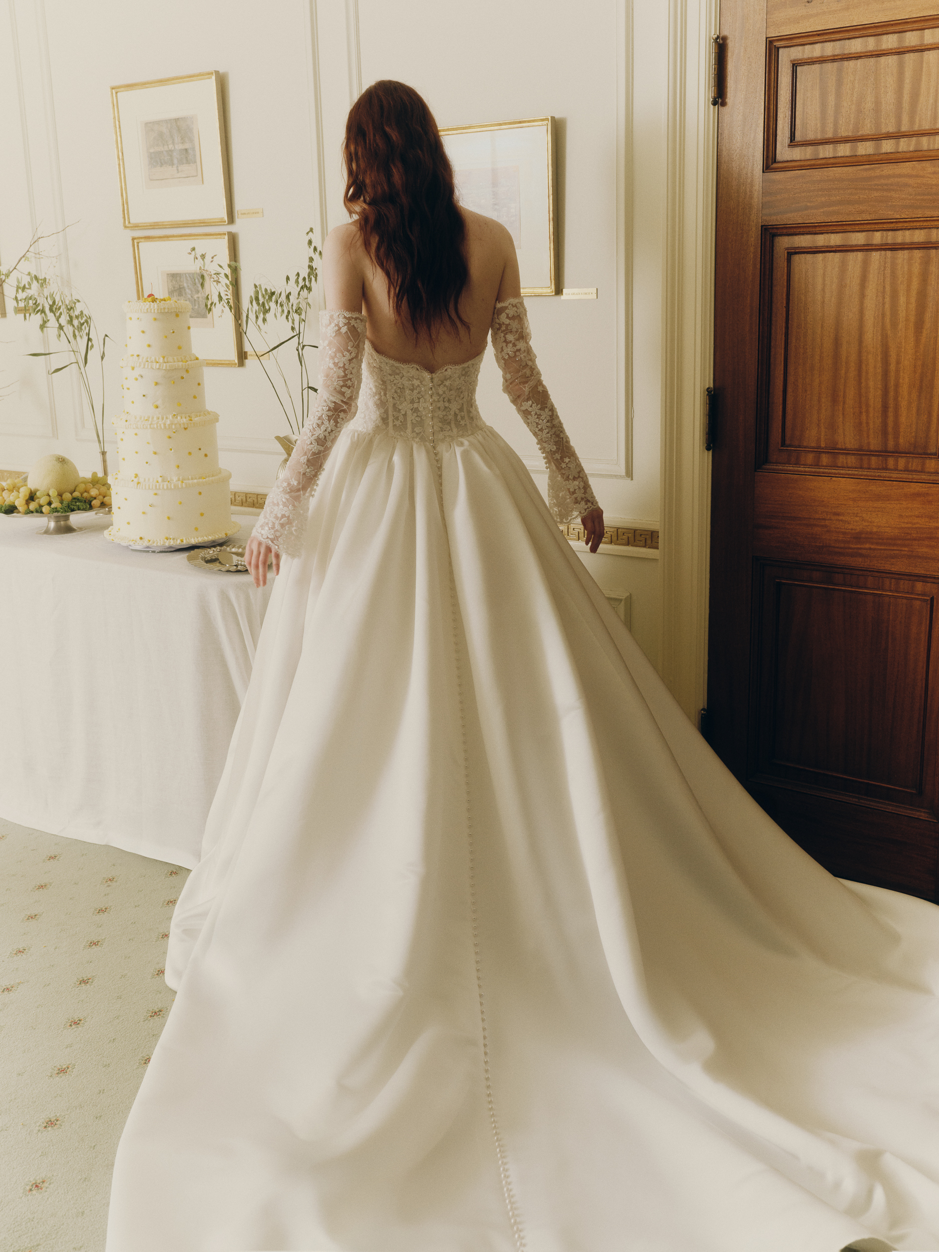 Back view of the Mabel ballgown, showing the voluminous satin skirt, lace opera cuffs, and flowing train.