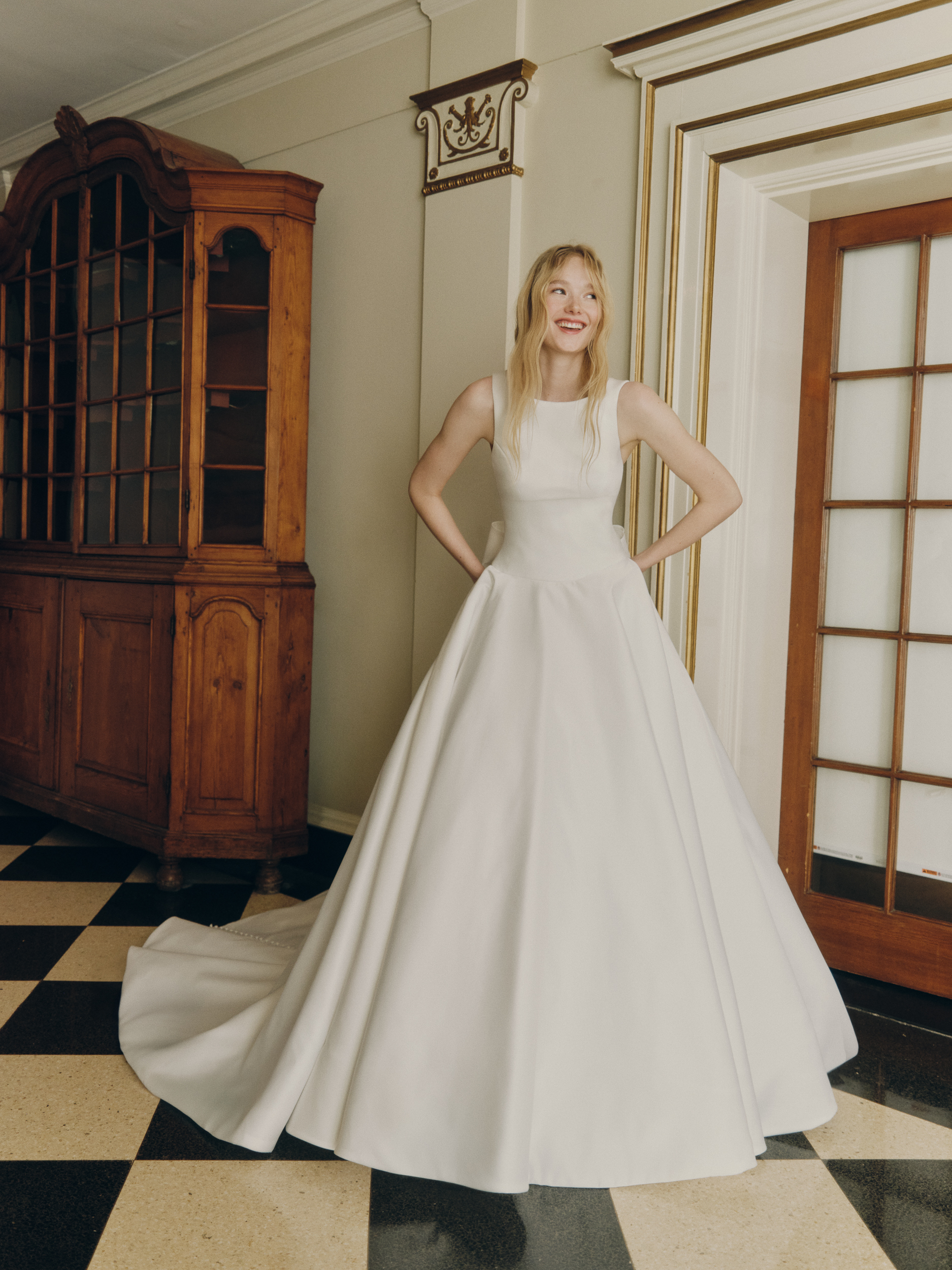 Bride wearing the Wynn drop-waist ballgown with bateau neckline, full skirt, and soft train.