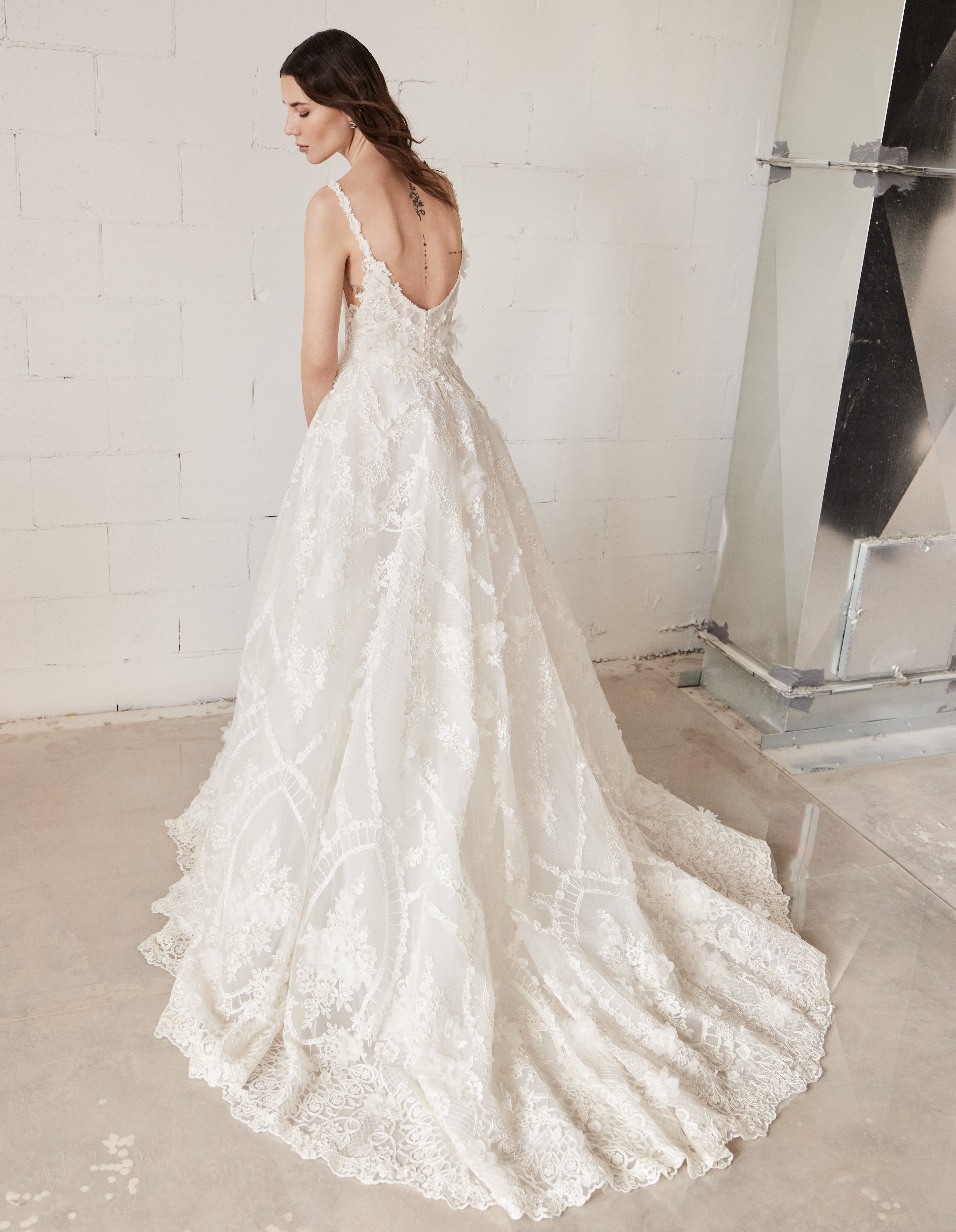 Bride wearing the Emmy ballgown from the side, showing the soft floral skirt and train.