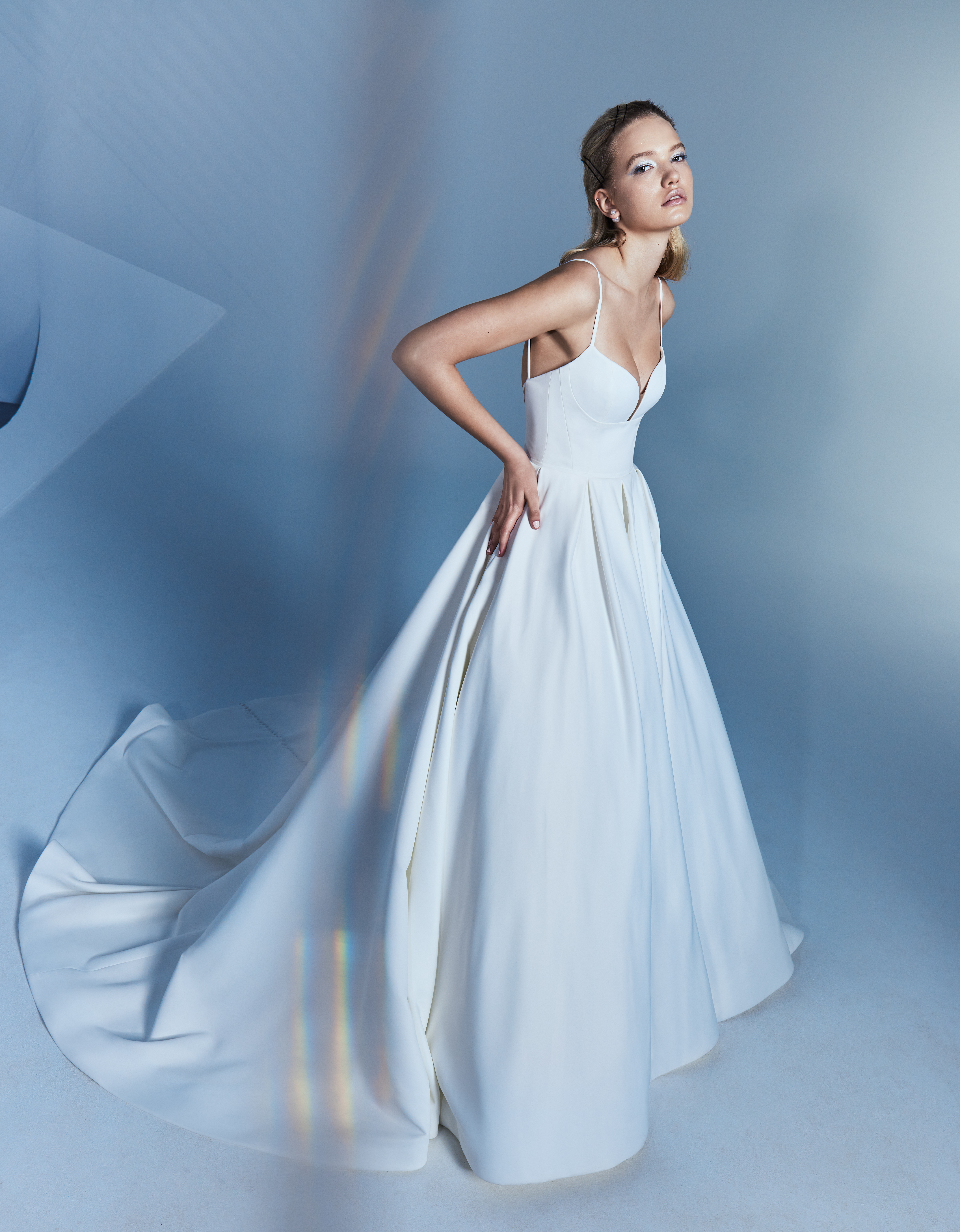 Side view of Lily matte satin ball gown with pleated skirt, spaghetti strap bodice, and buttons to hem.