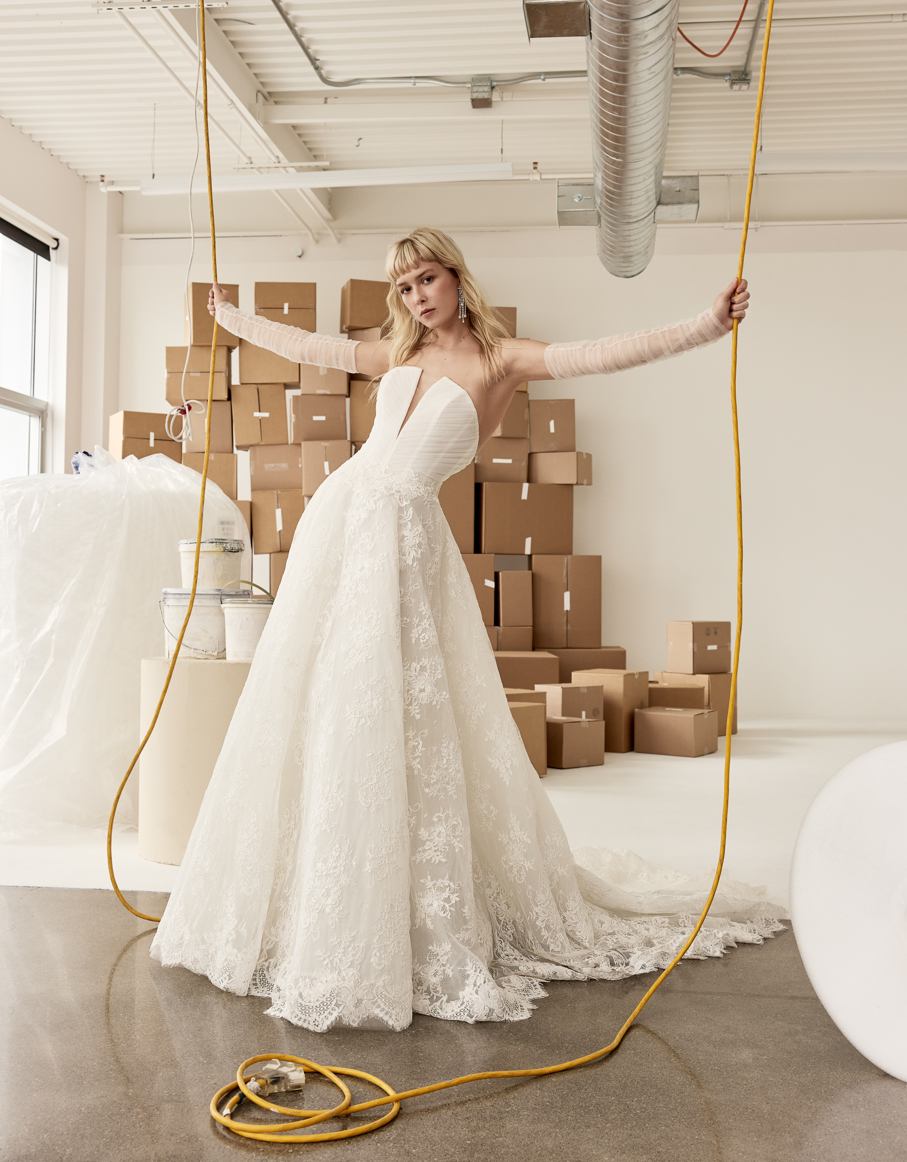 Blake A-line corded lace gown with plunging V-neckline, tulle draped bodice, and detachable ruched tulle arm sleeves, shown from the front.