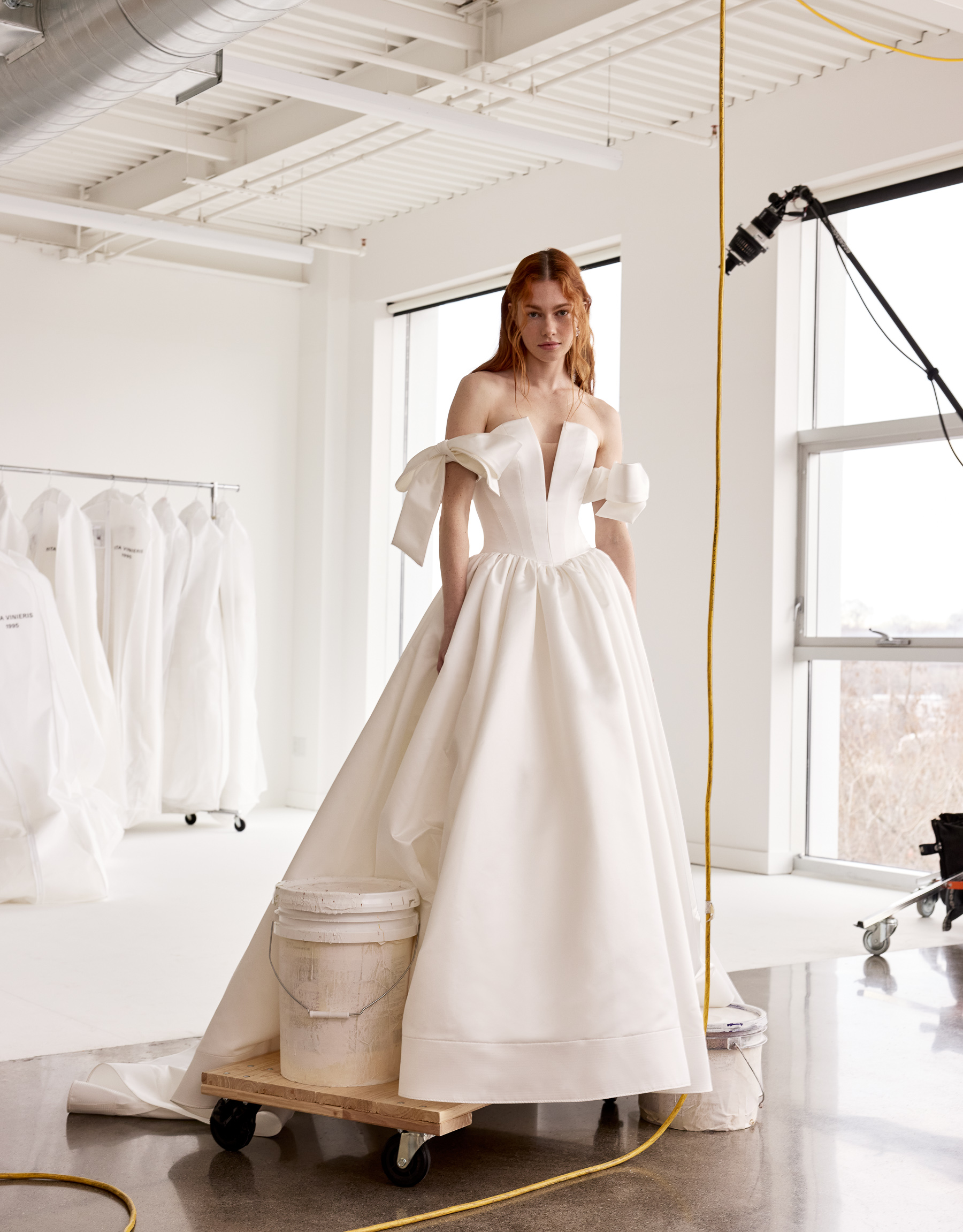 Danni satin ball gown with basque waist, plunging neckline, and detachable couture bow sleeves, shown from the front.