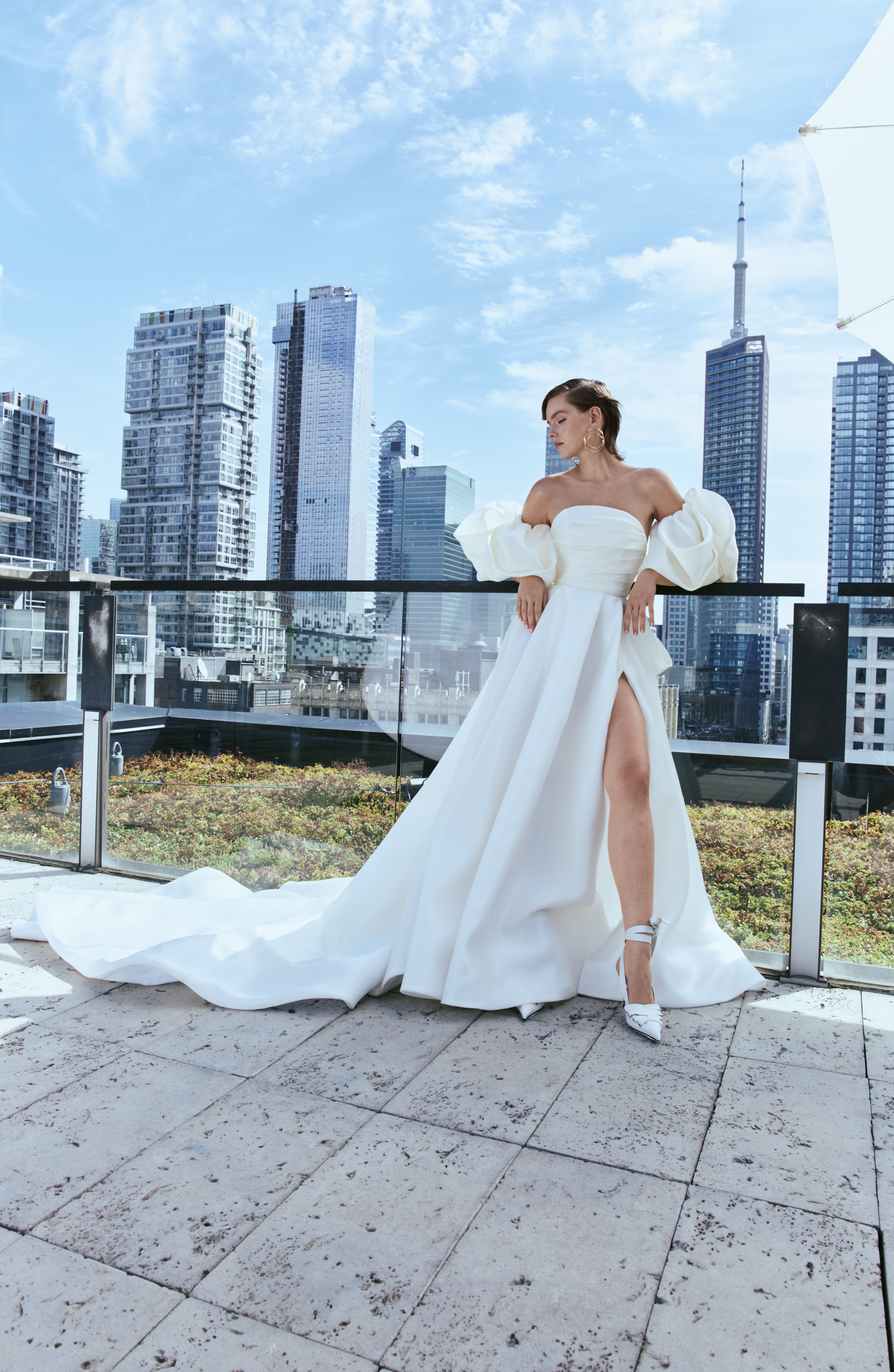 Lyric gazar satin silk ball gown with draped bodice, front slit, bow detail, and detachable pleated bubble sleeve, shown from the front.