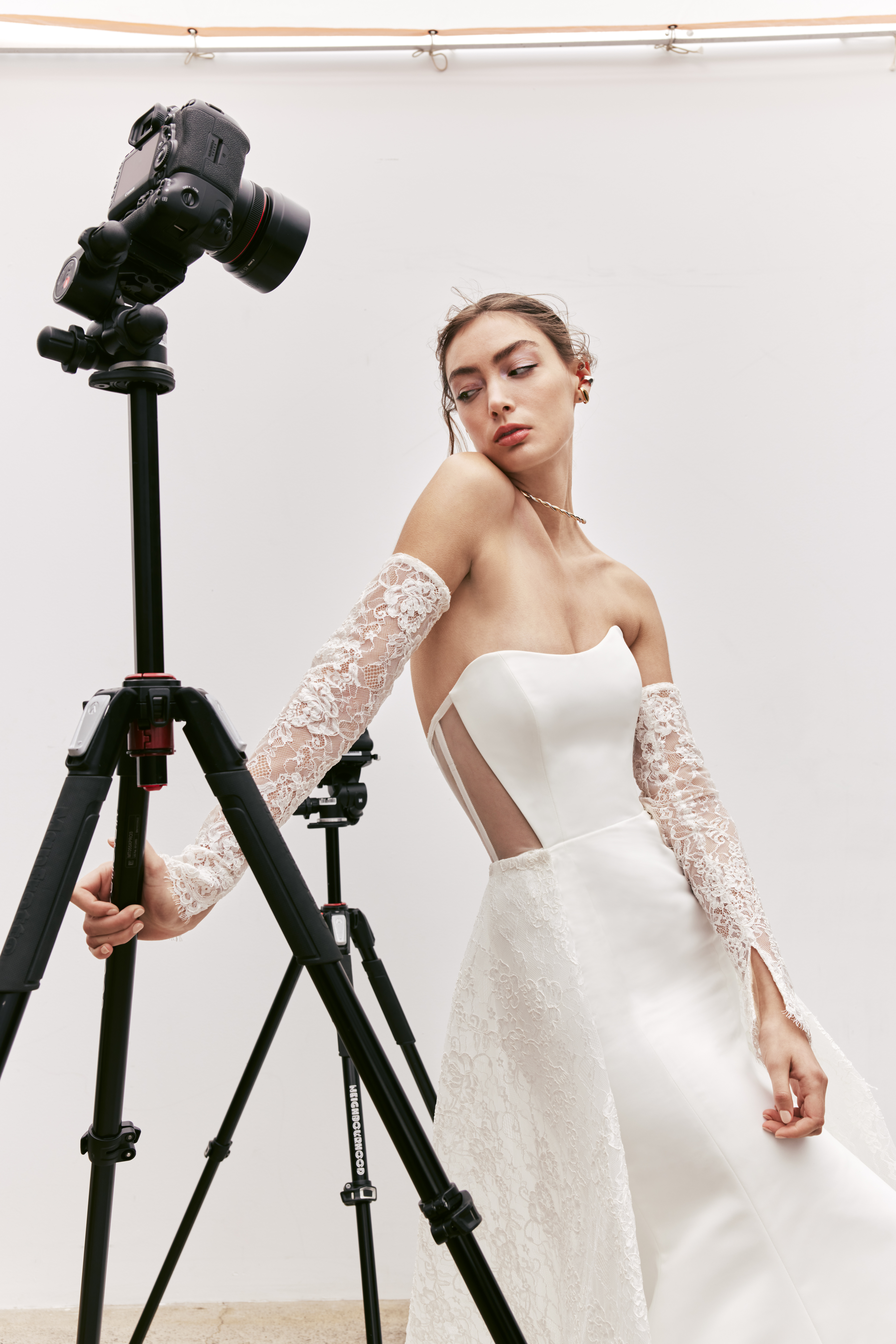 Rori strapless fit-and-flare gown with sheer back, exposed boning detail, corded lace overskirt, and sleeves, shown from the front.