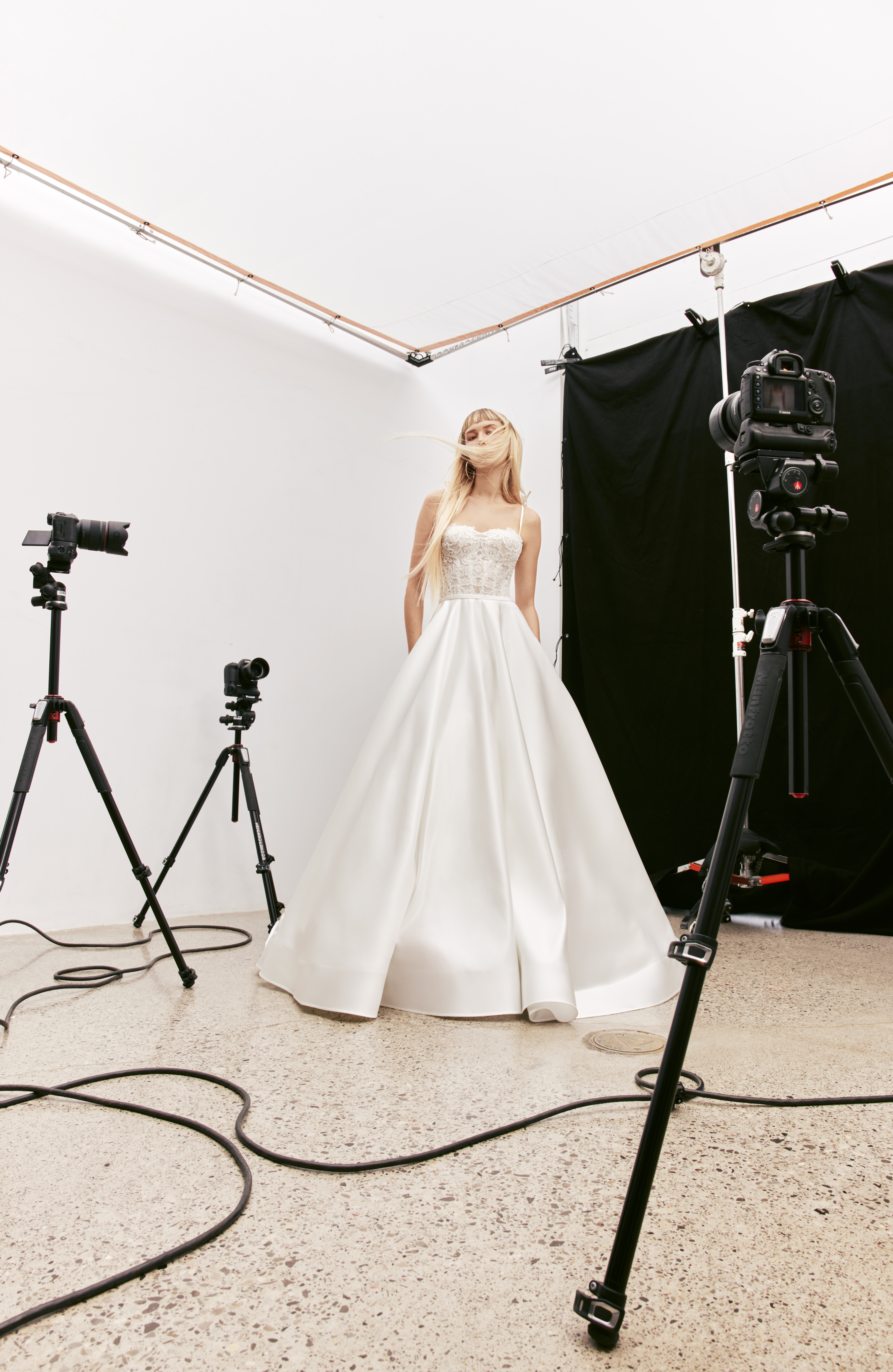 Indie corded lace corset ball gown with voluminous pleated satin skirt, sheer back, and love knot bows, shown from the front.