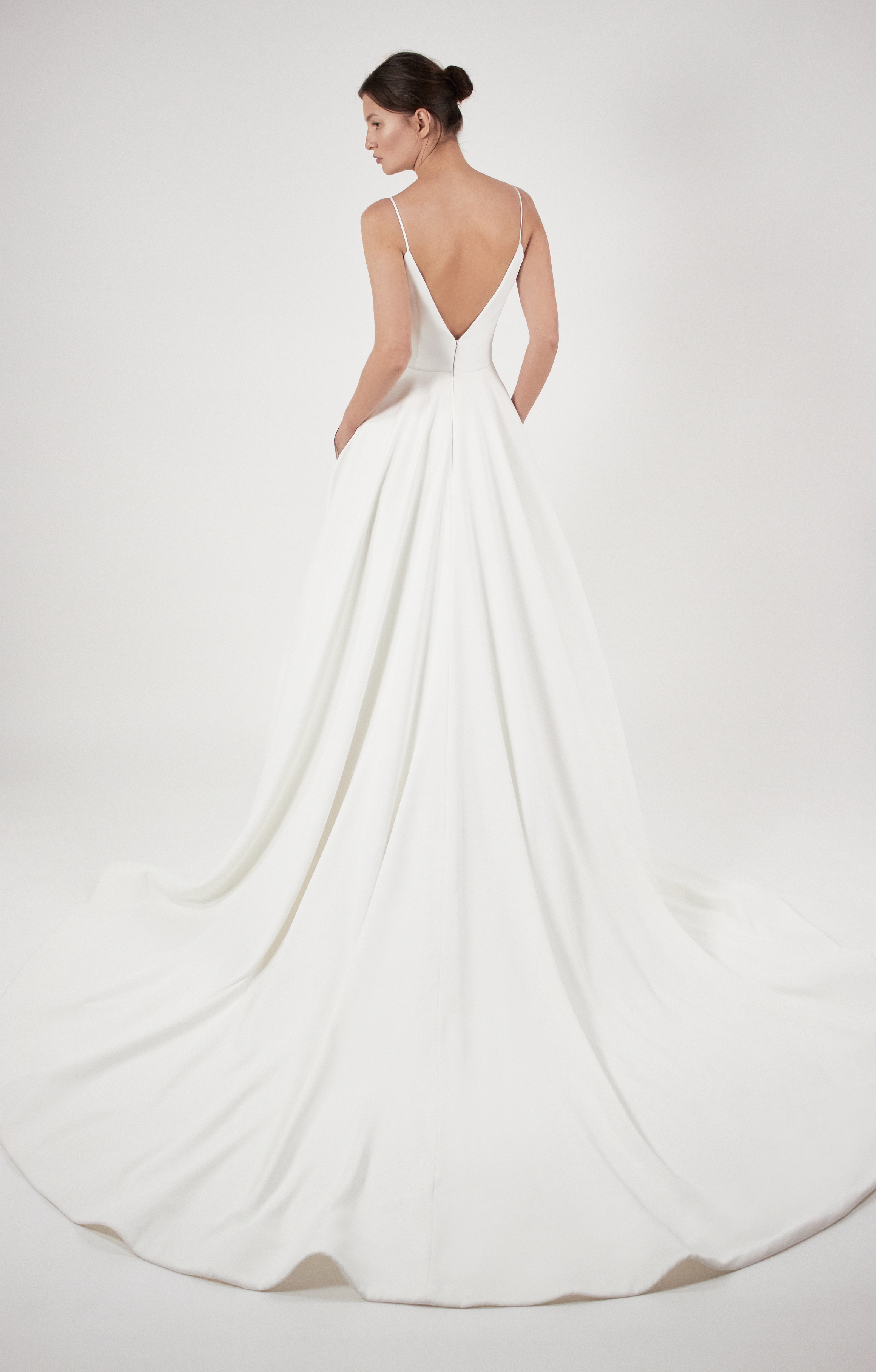 Back view of Layla ivory crepe ball gown with deep V ballerina bodice and full skirt.