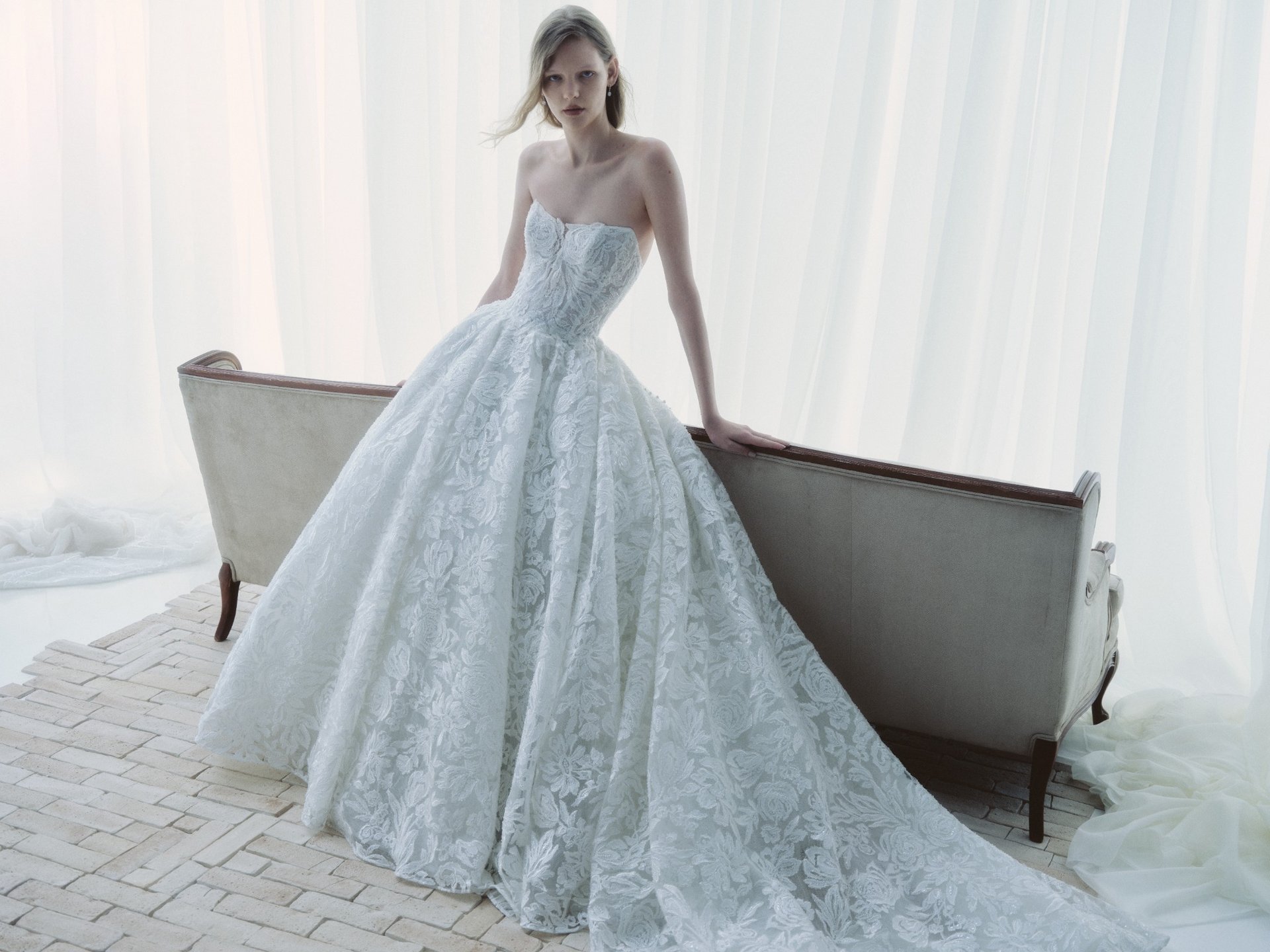 Breathe RIVINI FW26 strapless cat-eye ball gown in beaded laser-cut floral lace, shown close up from the front.