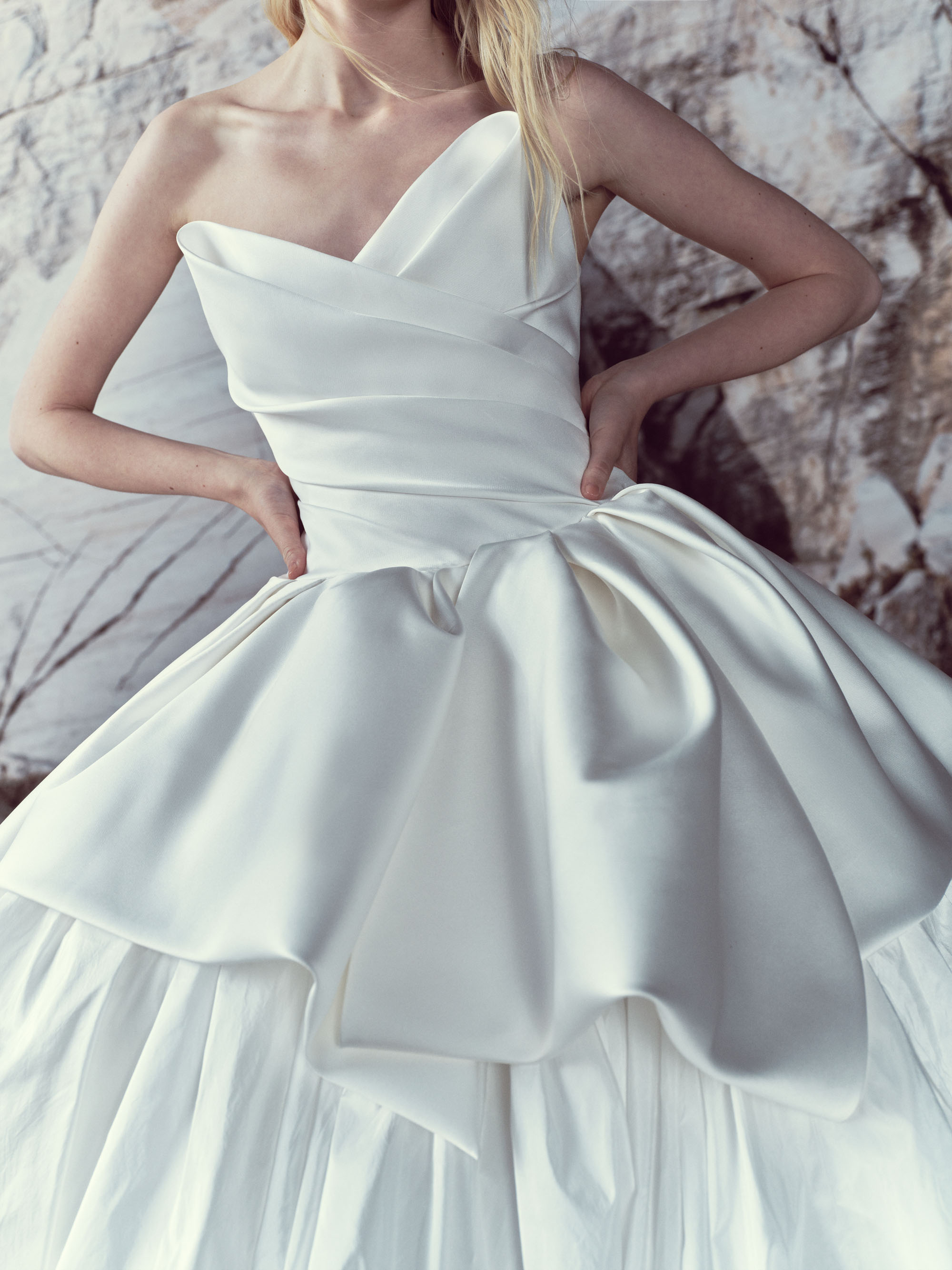 Close-up of Lucia showing the cat-eye bodice, rich sculptural draping, and cascading bow detail at the waist.