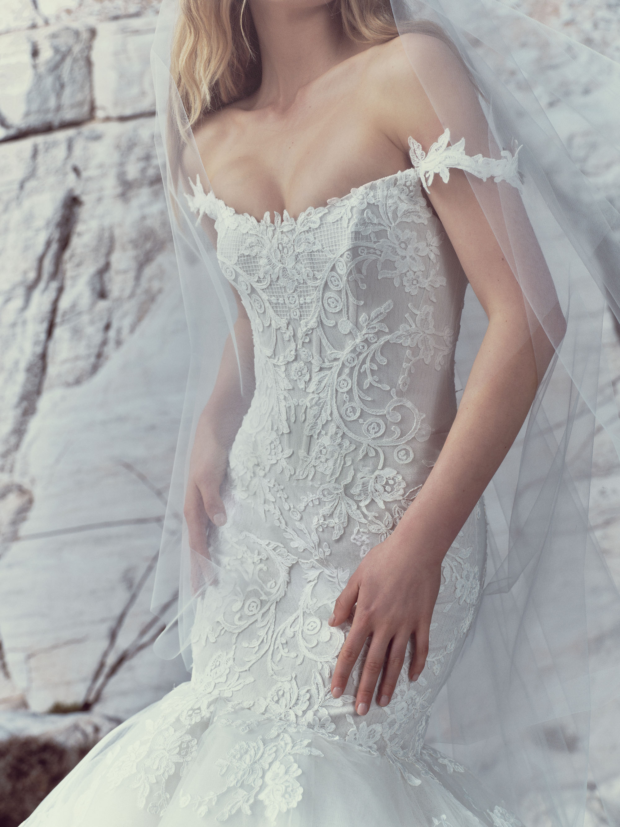 Close-up of Maren showing the hand-applied Alençon lace, off-the-shoulder floral strap, and fitted bodice.